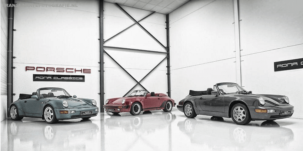Drie Porsche 911 cabriolet auto's in een witte showroom, met Porsche en Rona Classics borden aan de muur.