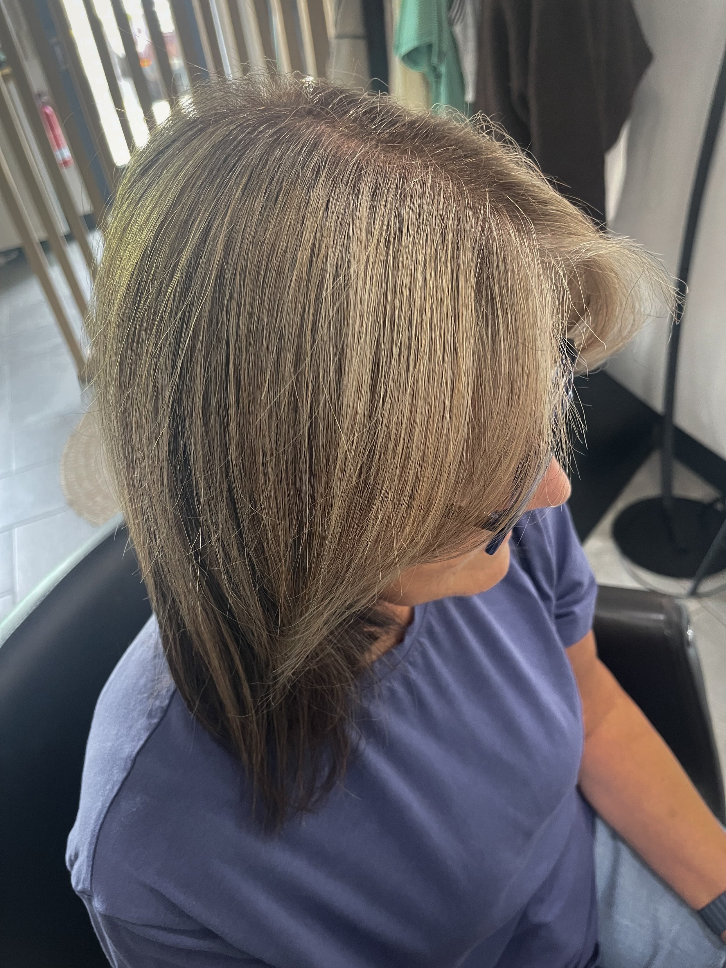 Woman with freshly highlighted hair that mimics her natural grey pattern for a softer grey grow out. 