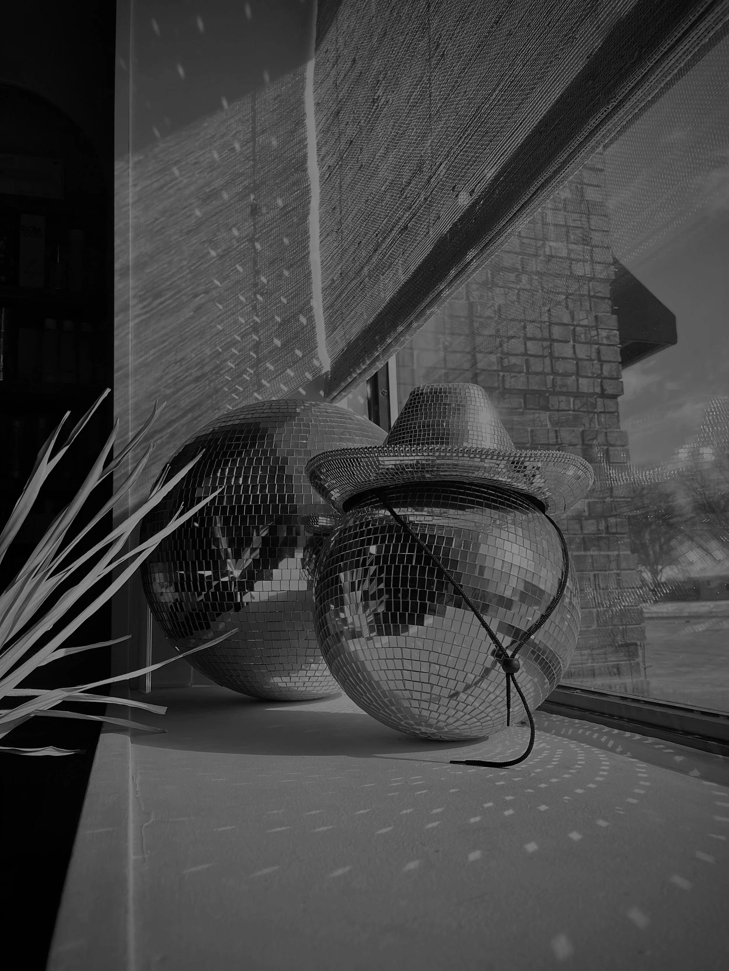 window sill with two disco balls and a cowboy hat