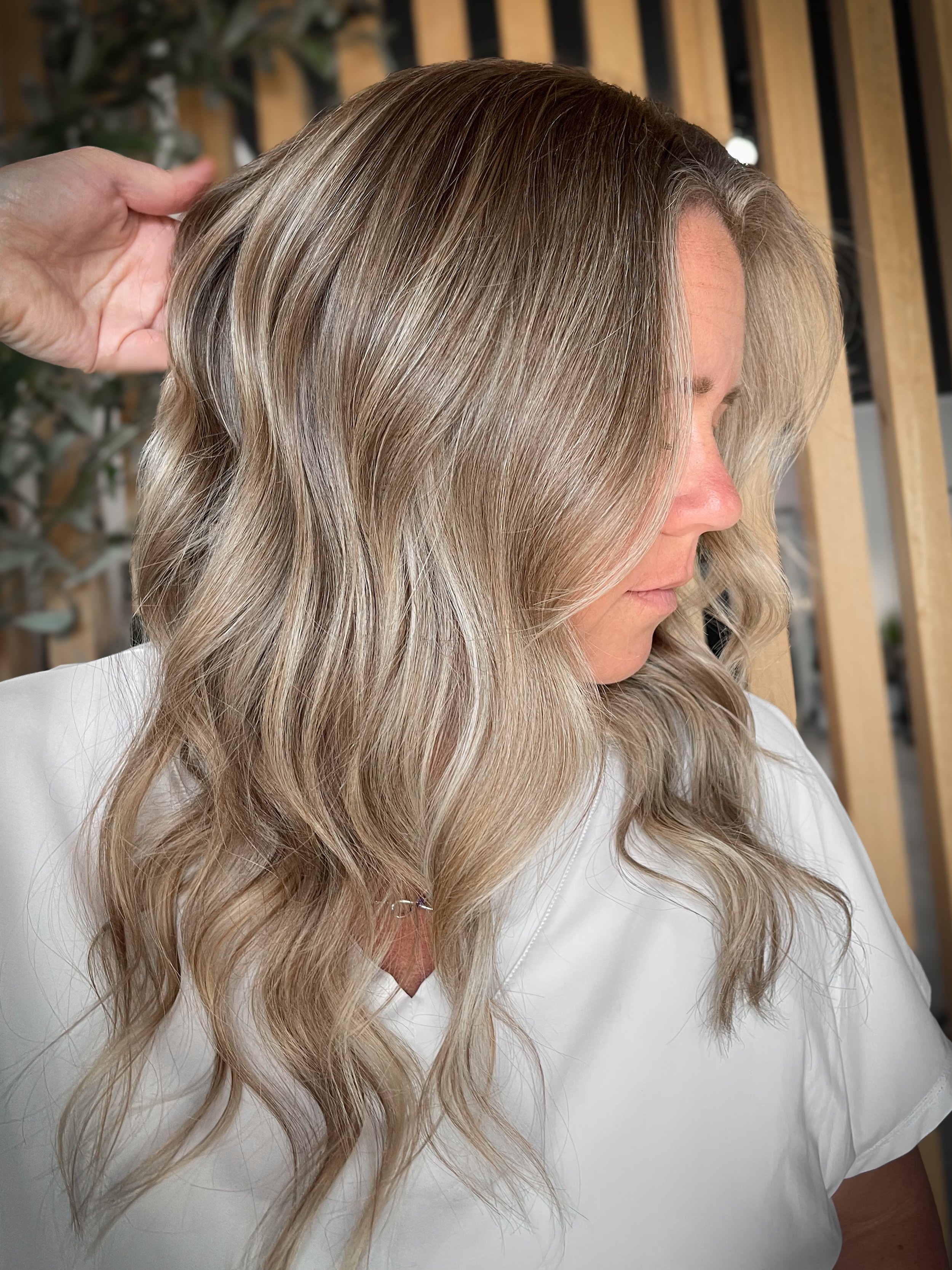 Women posing while showing off her Bronde lived in hair color. 