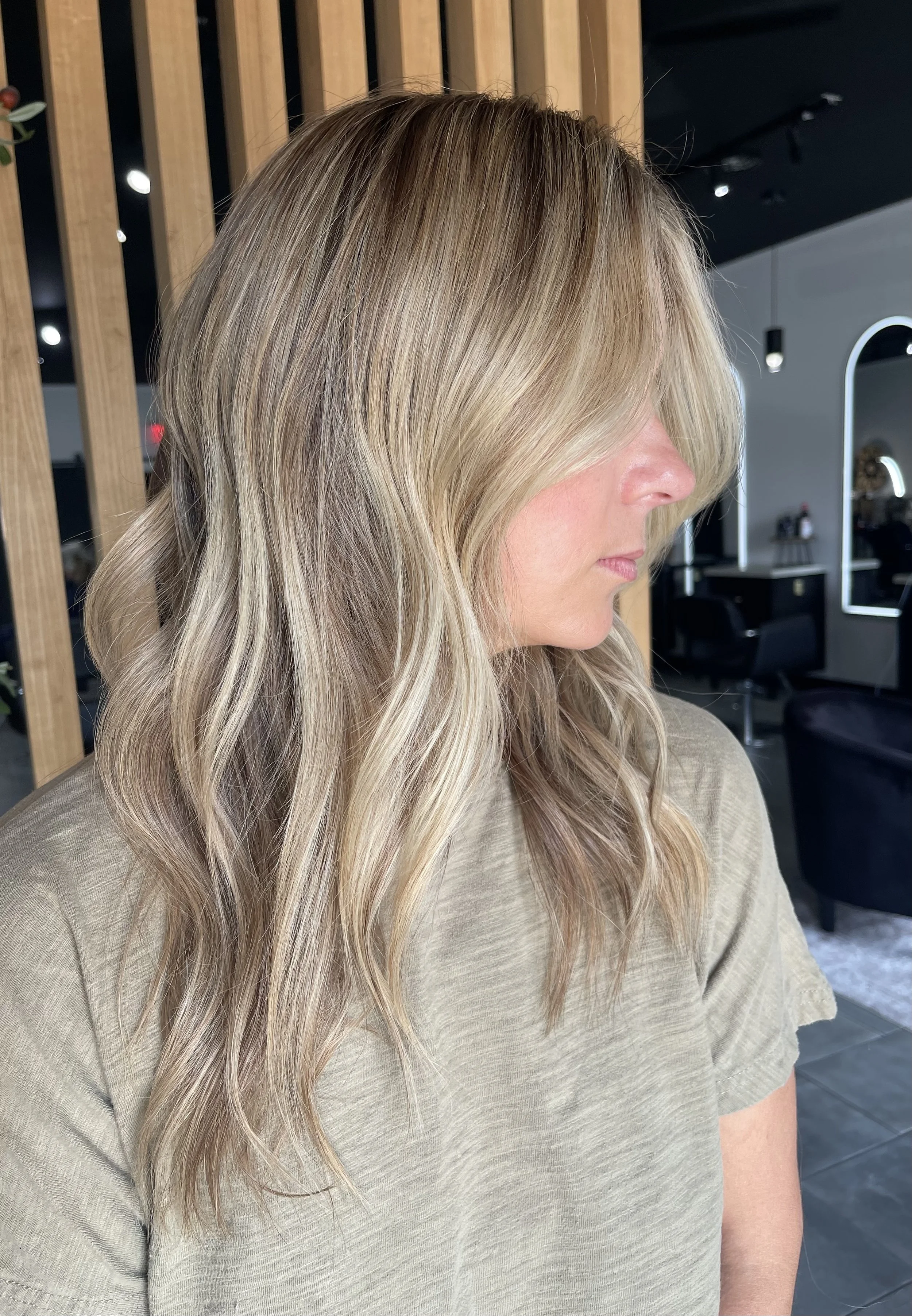Young mom posing while showing off her blonde lived in highlights. 