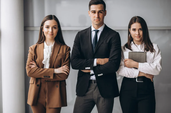 Group of professionals two women and a man in professional attire crossing their arms
