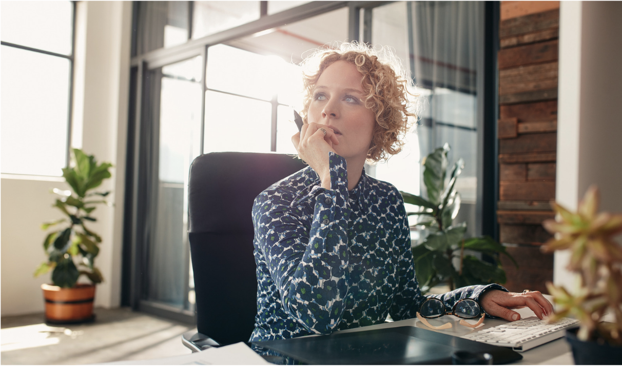 Blonde woman at computer desk contemplating her choices