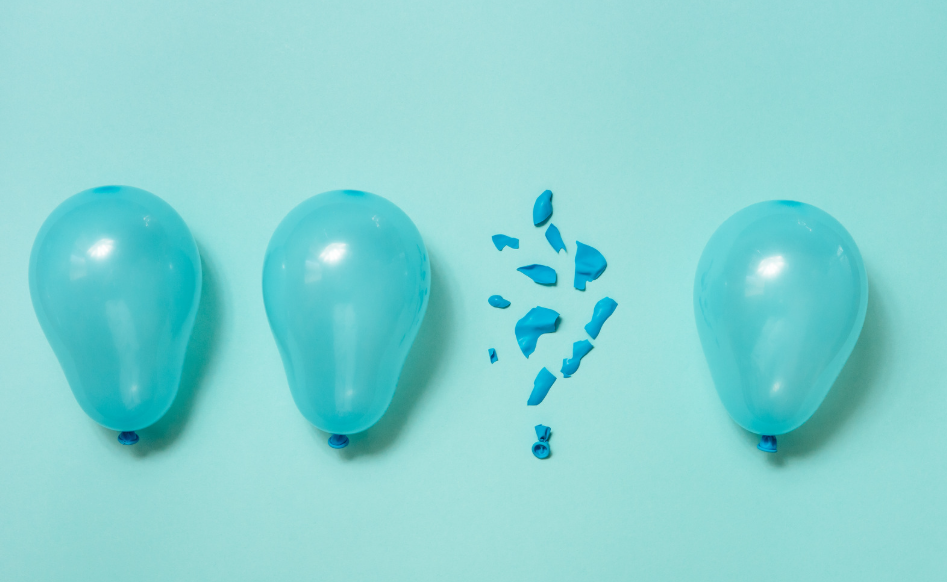 Aqua colored balloons on a turqouise background with one popped in the middle