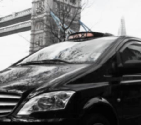 Close-up of the front of a black train with city buildings in the background.