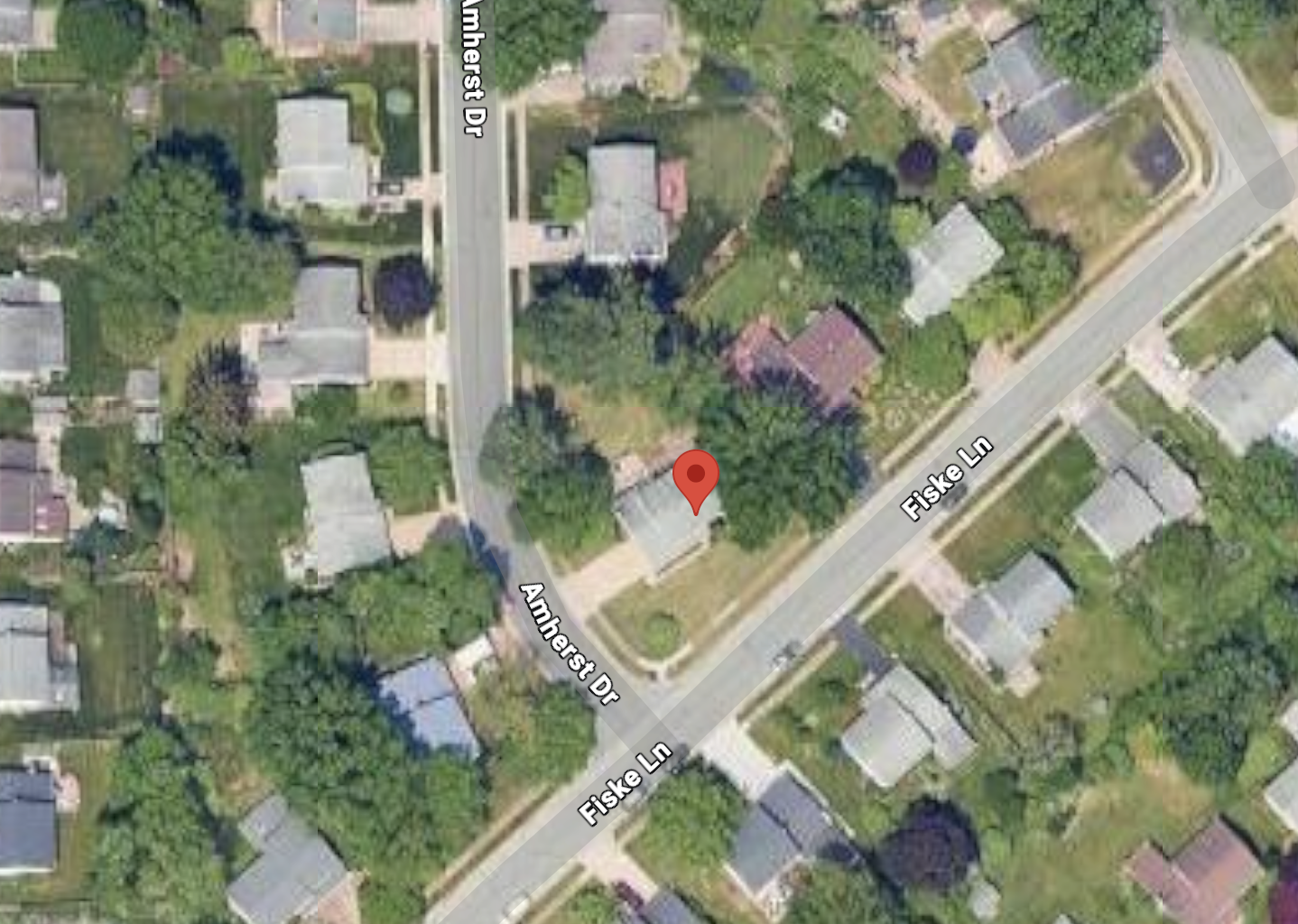Aerial view of a residential neighborhood showing houses, trees, and streets named Amherst Drive and Fiske Lane.