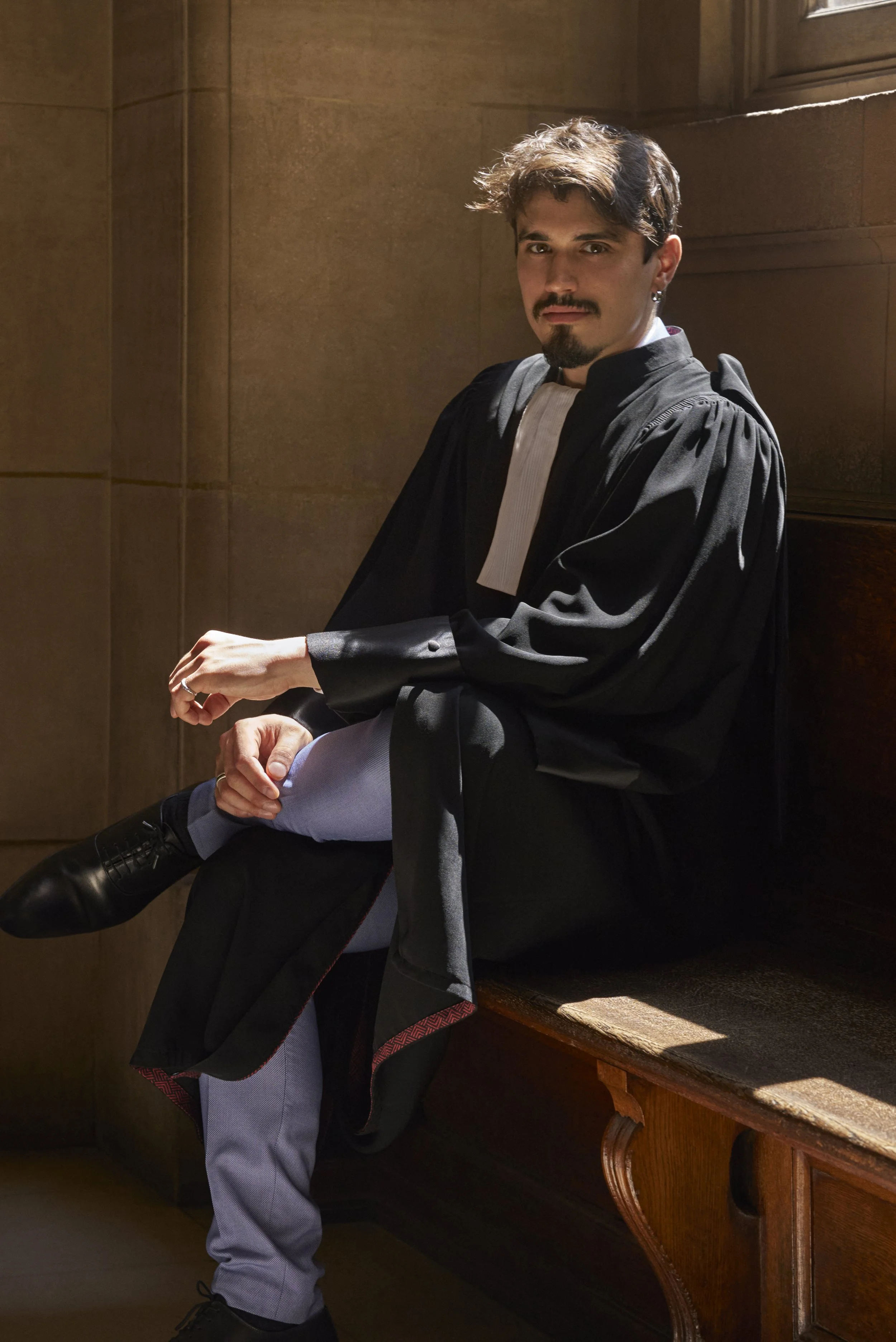 Avocat en robe assis sur un banc en bois dans un palais de justice