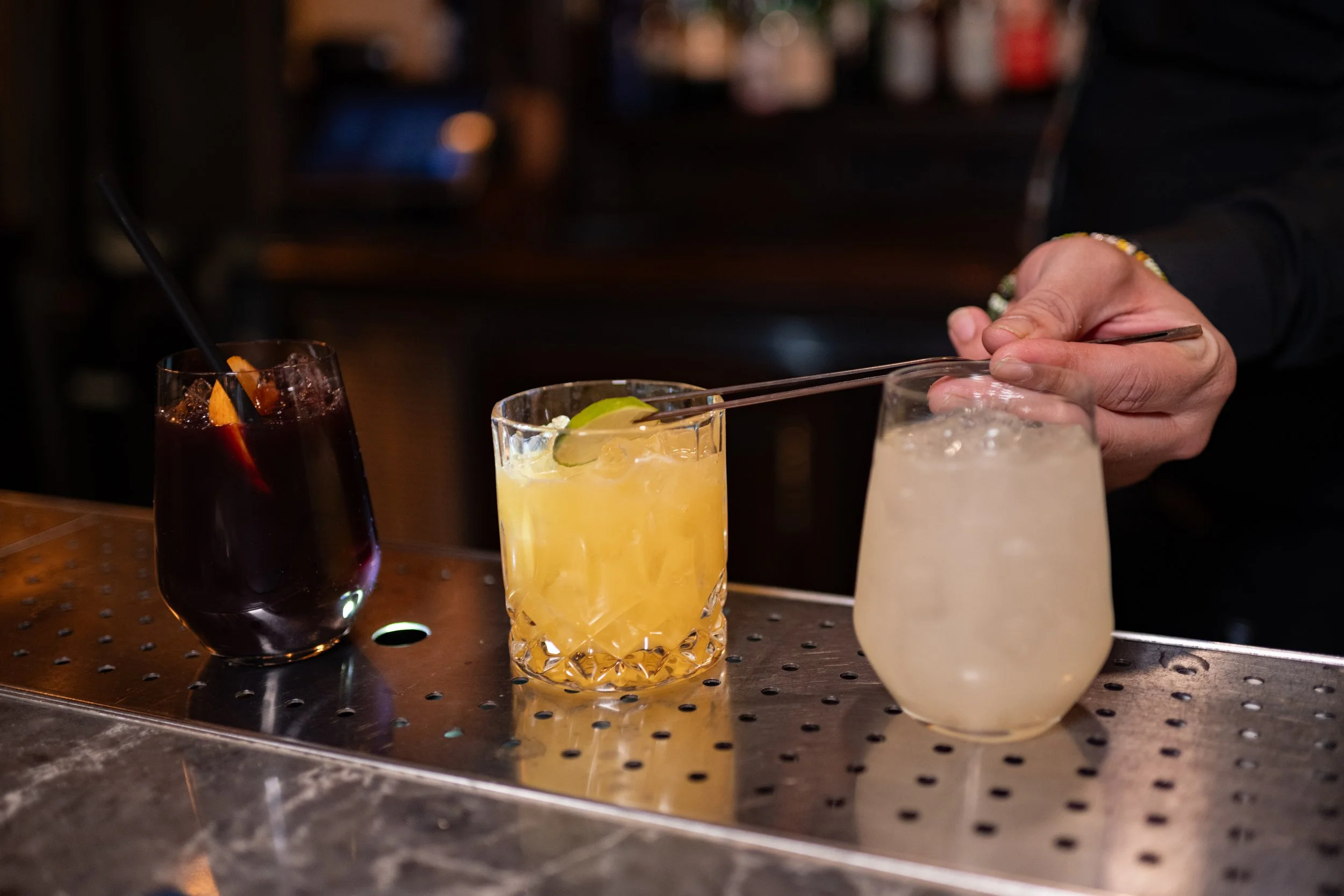 Bartender preparing craft cocktails at The Hemingway Steakhouse bar.