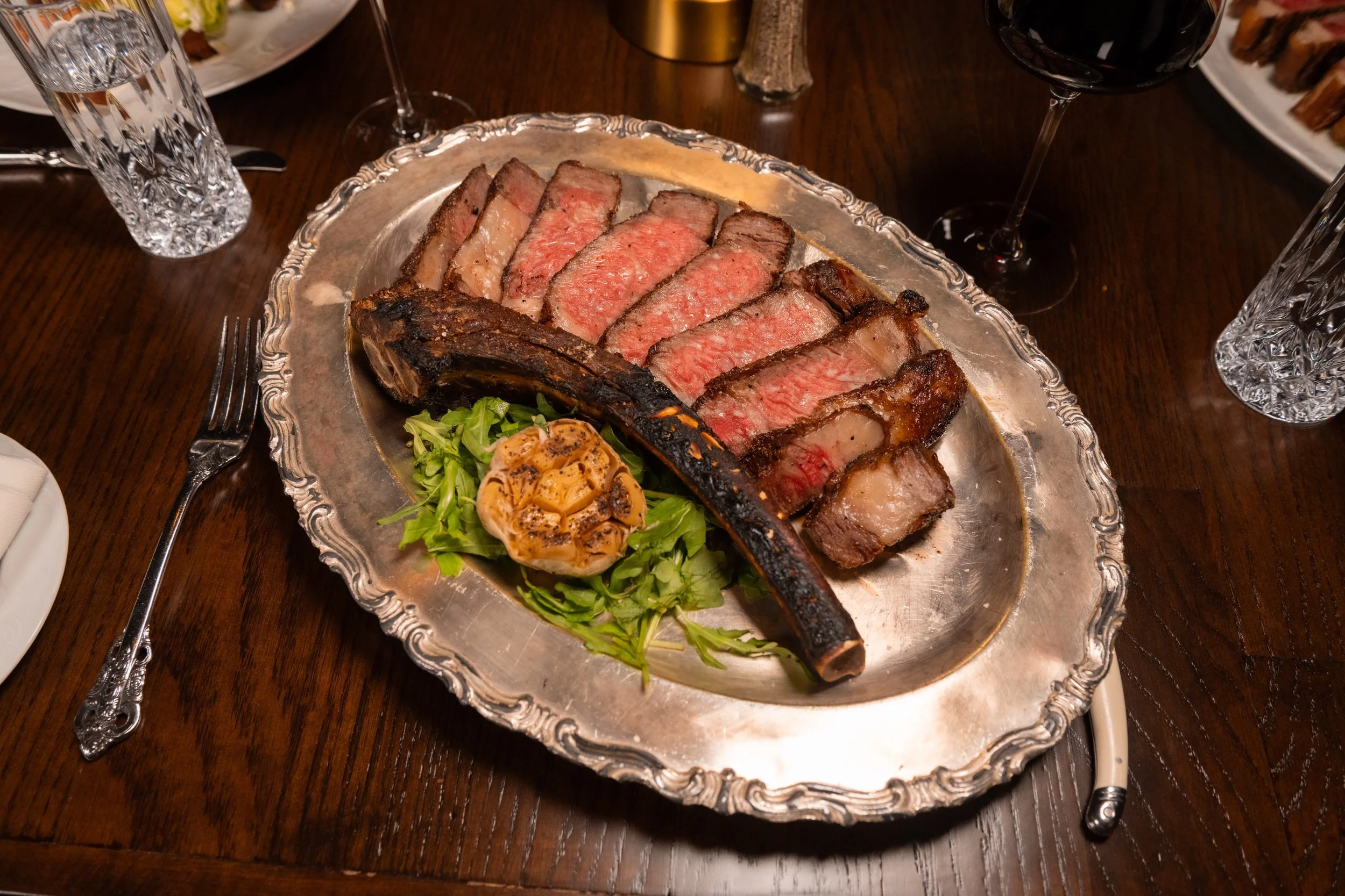 Sliced steak entrée with classic accompaniments at The Hemingway Steakhouse.