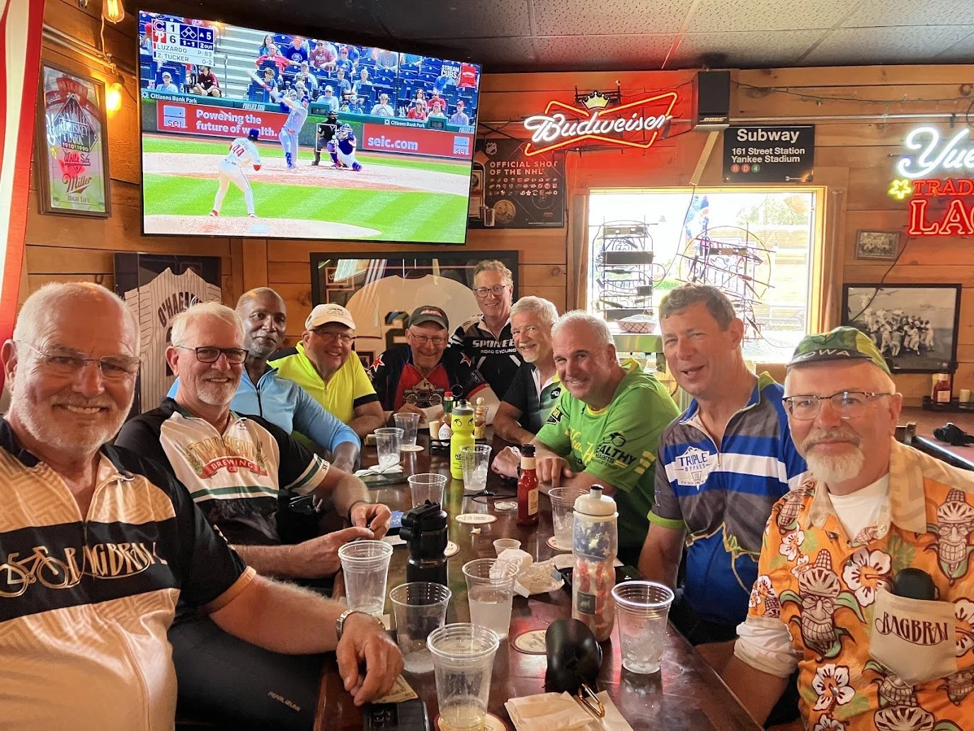 Image of a group of gentlemen (9) gathered at a sports bar smiling at the camera
