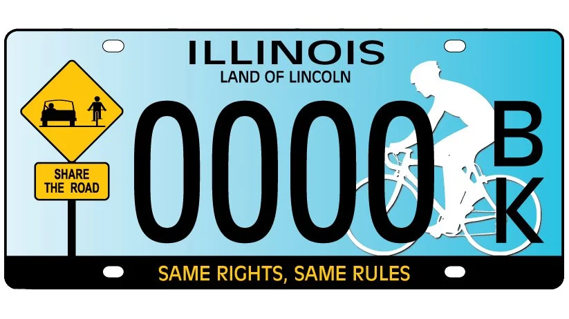 Image of Illinois License Plate, featuring a white silhouette of a bicyclist, a yellow traffic sign saying "Share The Road", and a banner at the bottom saying "Same Rights, Same Rules".