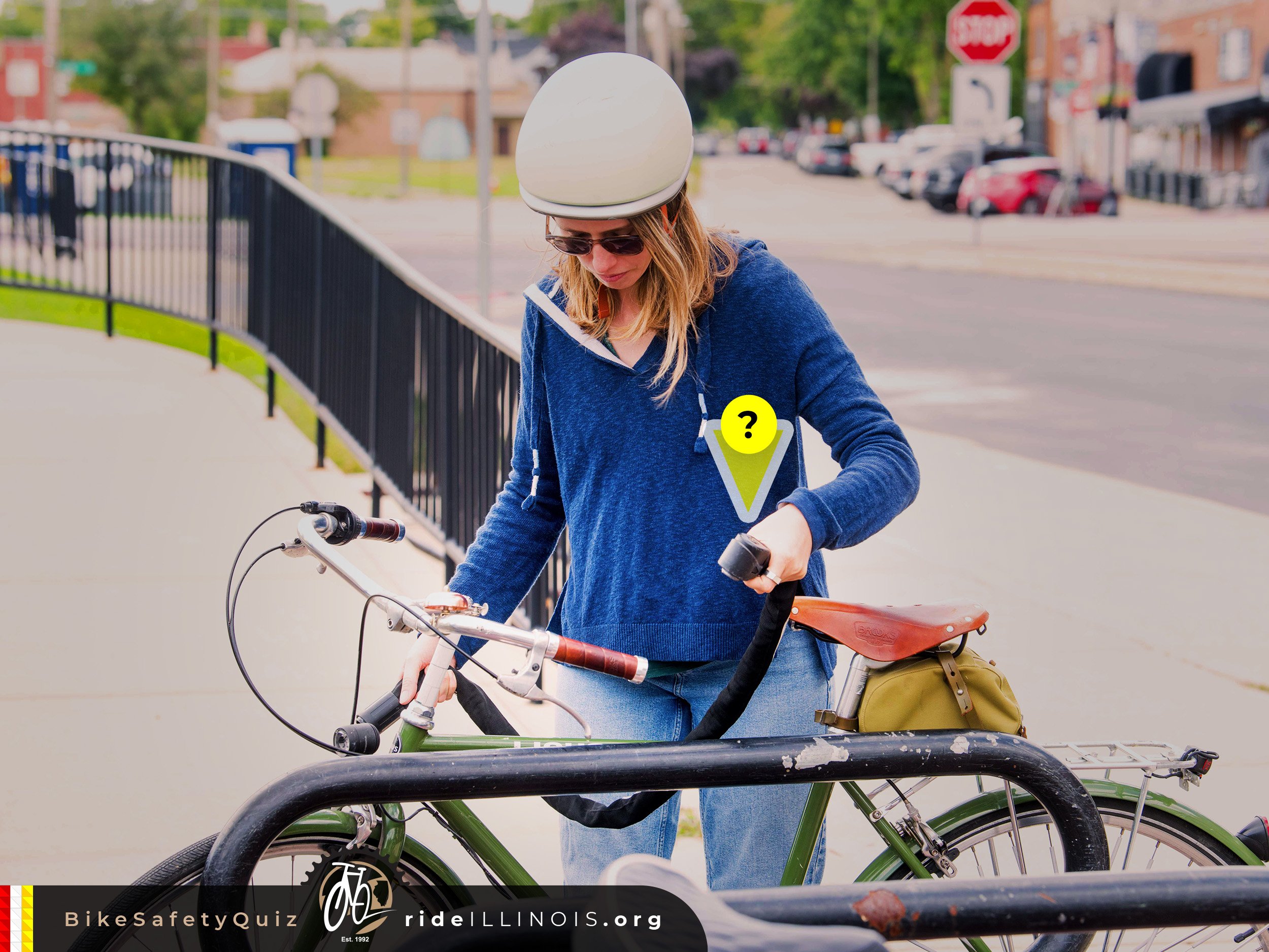 Woman seen wearing a helmet in front of a bike rack with her bike.  There is a yellow triangle labeled "?" pointing towards the bike lock in her hands.