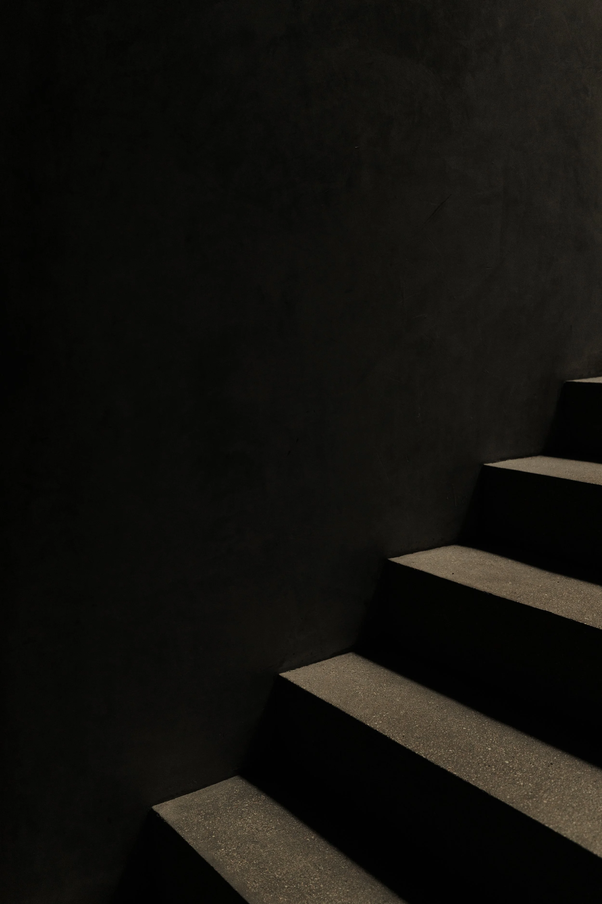 Dark staircase with illuminated steps, creating a contrast between shadows and light.