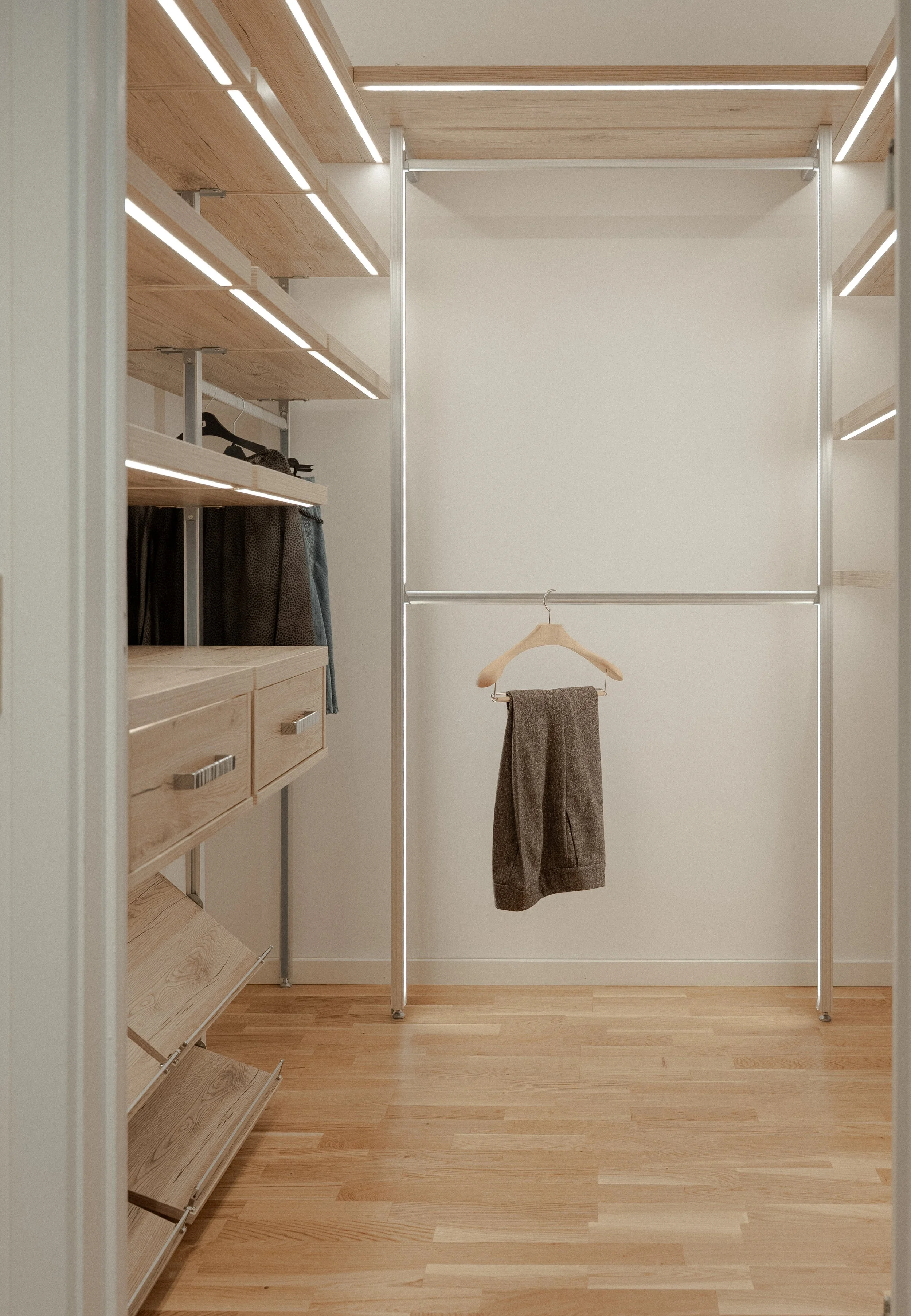 Eksklusiv walk-in garderobe på mål med specialfremstillet opbevaring og integreret LED-belysning.
