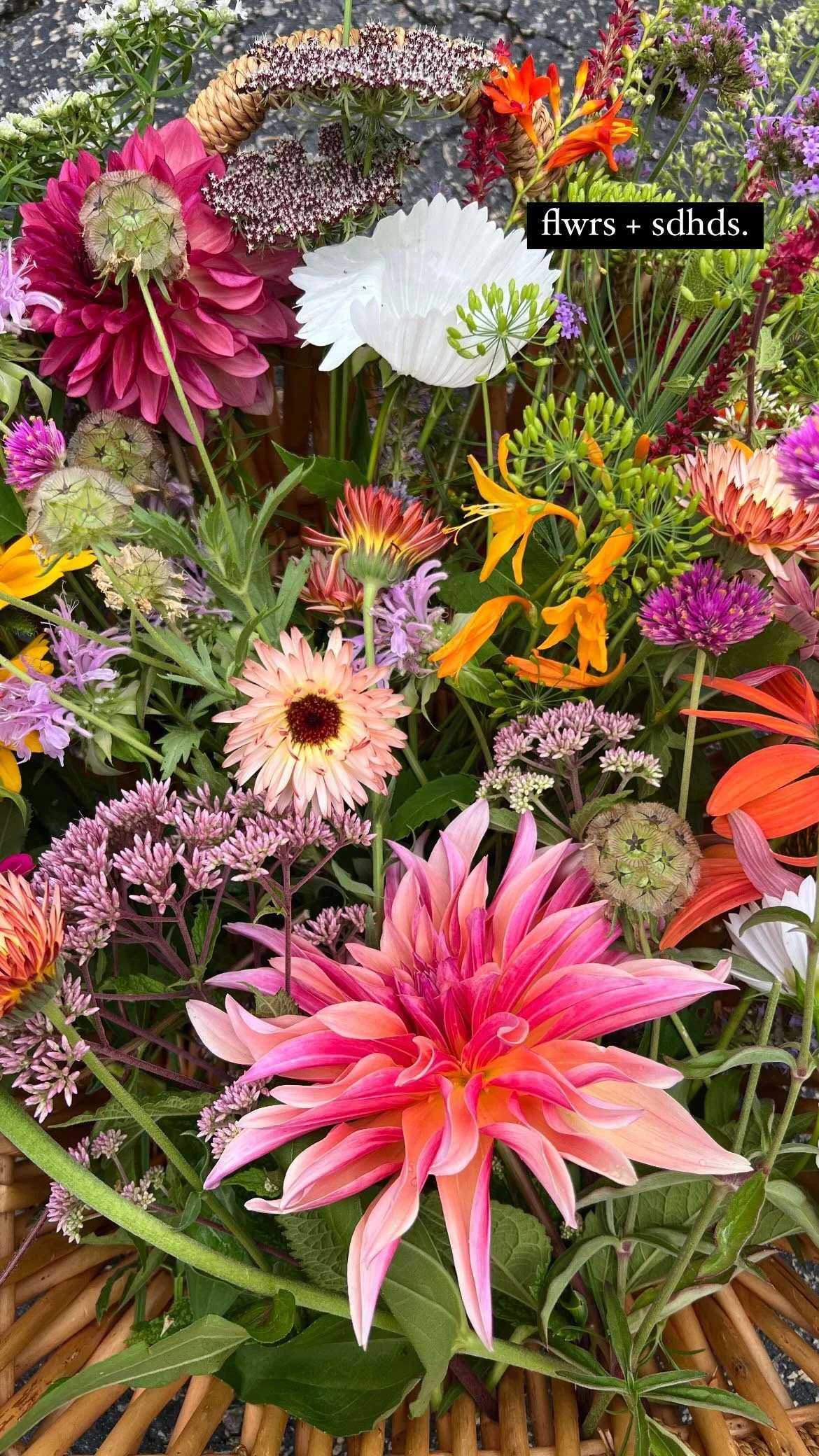 Colorful bouquet of various flowers including dahlias, lilies, and other mixed flowers in a basket.