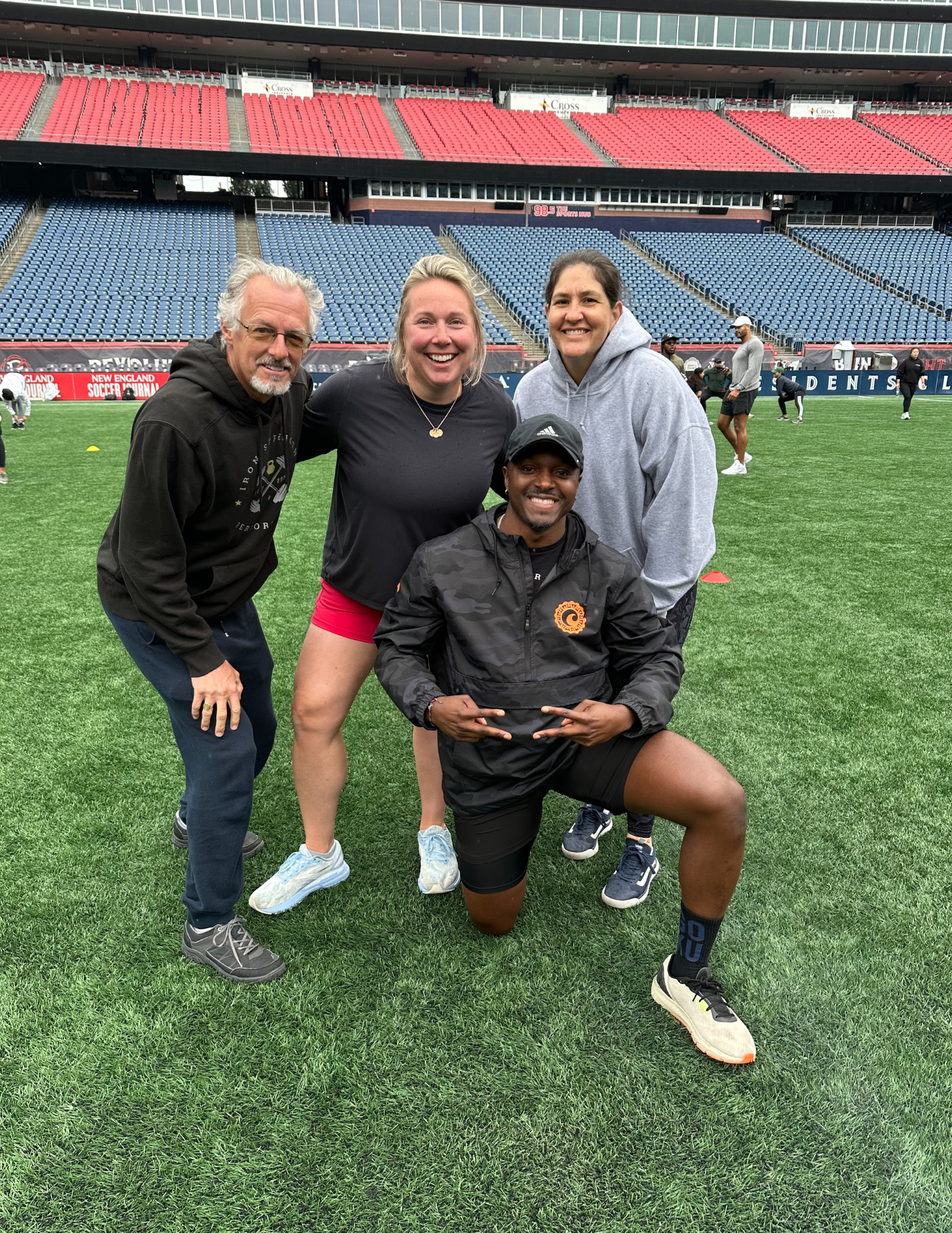 fitness coach on football field with personal training clients