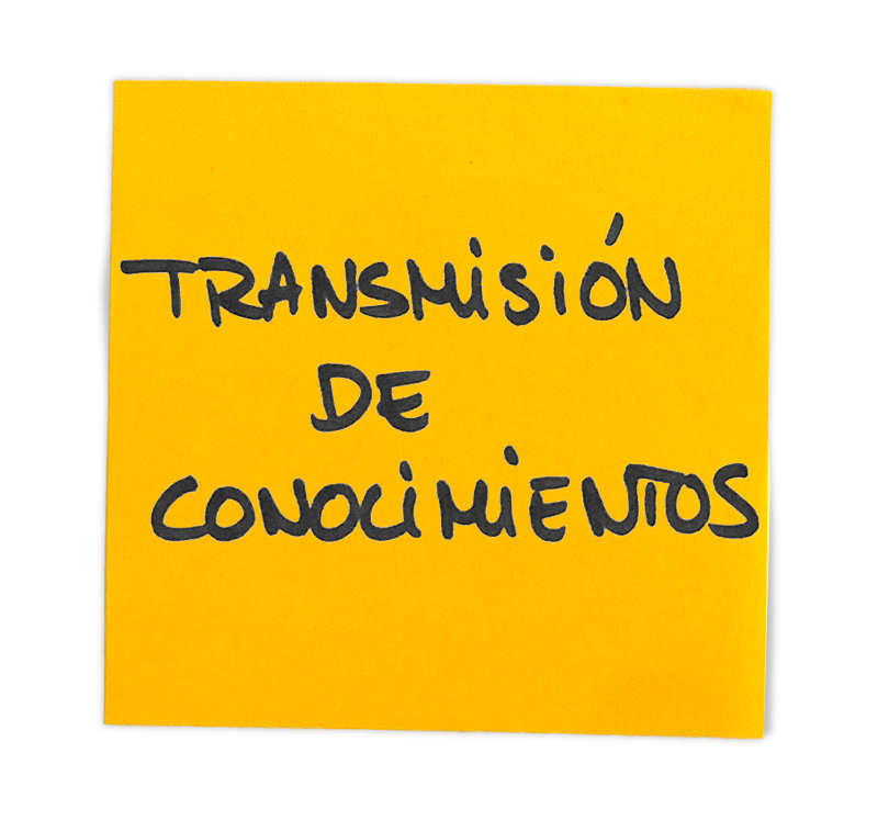 Nota adhesiva amarilla con la frase "Transmisión de conocimientos" escrita a mano en negro.