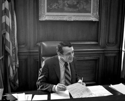 Harvey Milk sitting at desk in his political office