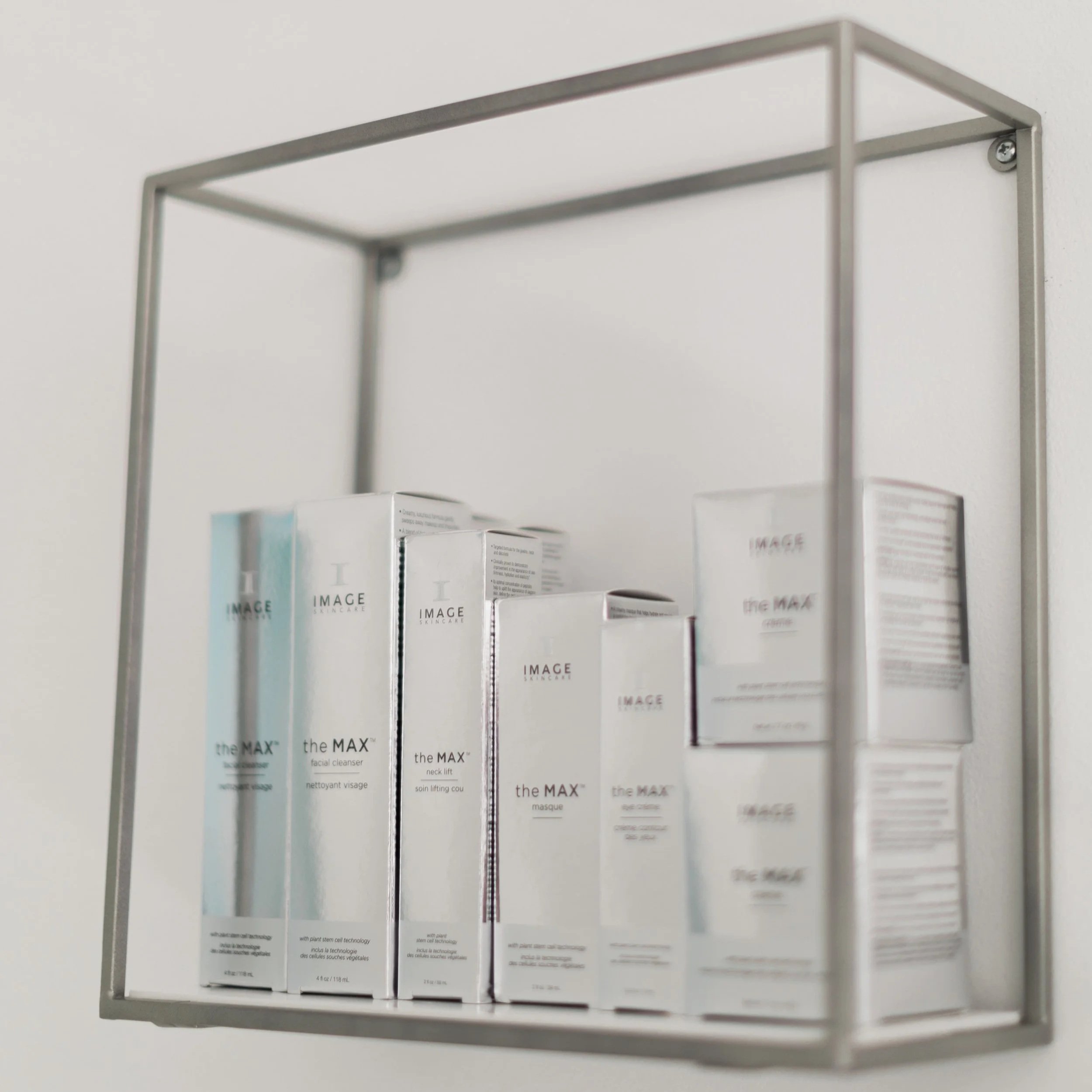 A metal shelf mounted on a wall holding several boxes of skincare products labeled 'the MAX' by IMAGE skincare.