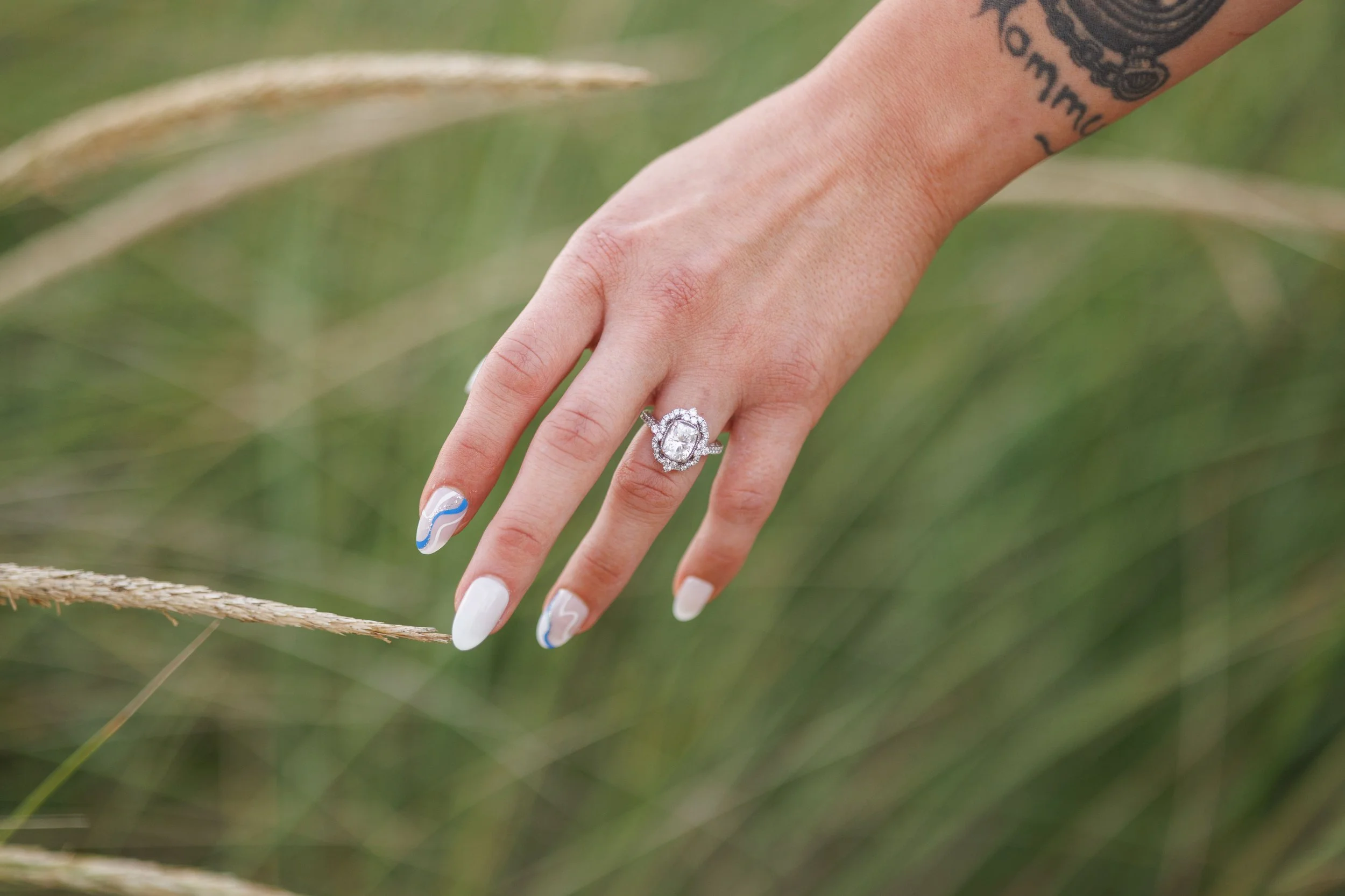 Bride and groom dancing outdoors near flowers in a field at sunset.