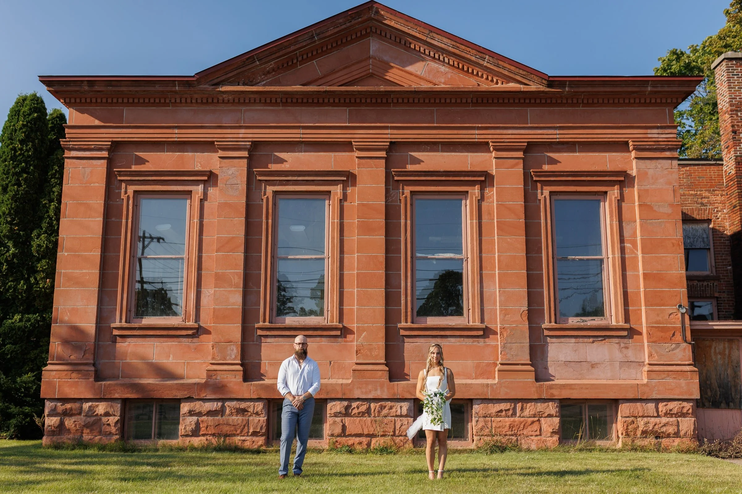 husband and wife stand in front of old public library