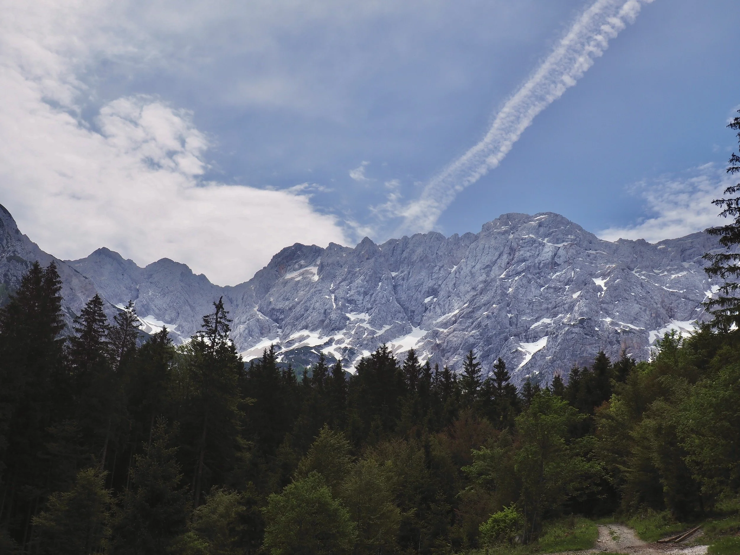 Snow-covered Planšarsko Jezero alpine peaks above a forest in Slovenia