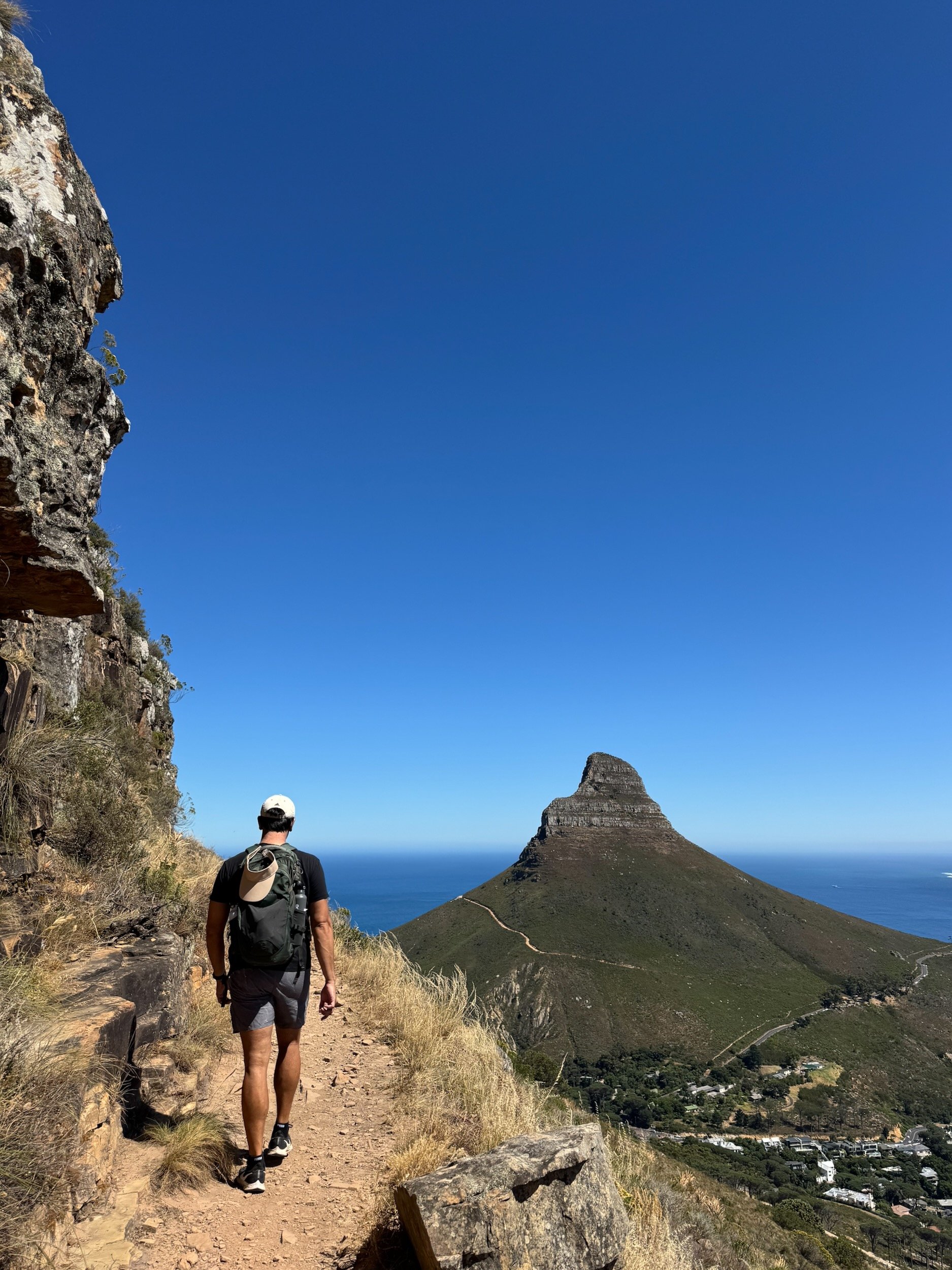 hiker overlooking Lion’s Head and the Atlantic from Kloof Corner