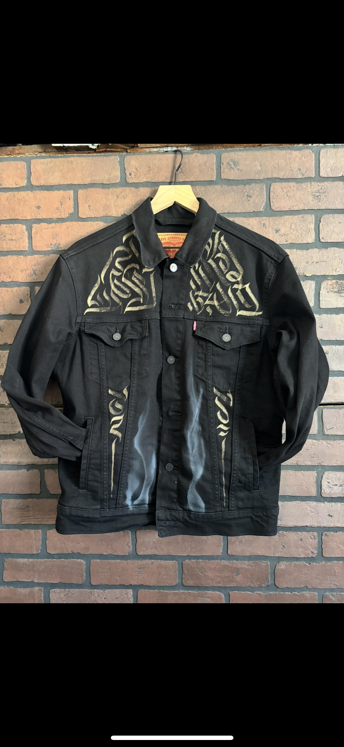 One-of-one hand-painted black denim jacket with airbrushed ghost orchid and bleach calligraphy pattern.