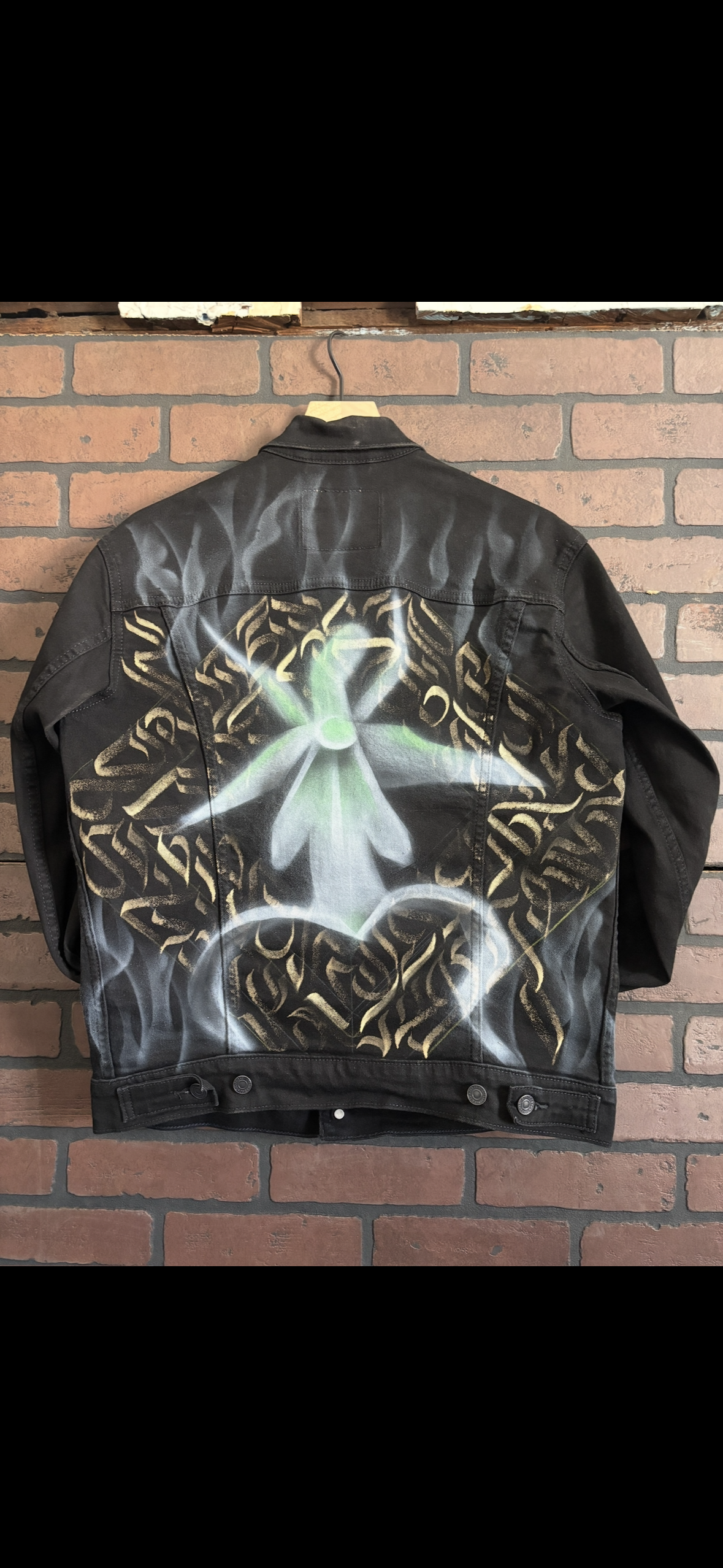 One-of-one hand-painted black denim jacket with airbrushed ghost orchid and bleach calligraphy pattern.