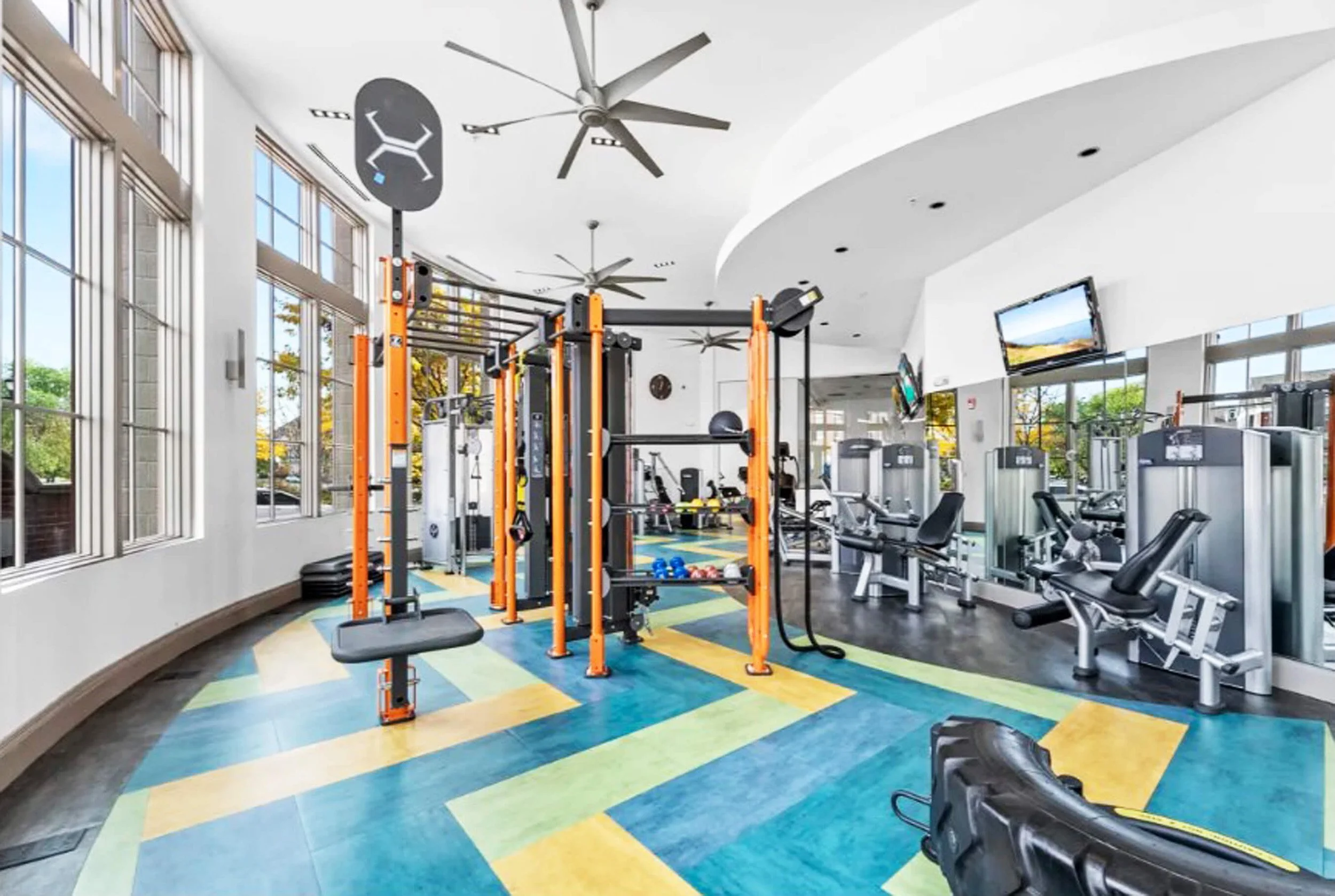 Residential fitness center design in Bayonne NJ with custom flooring pattern and fan-shaped layout.