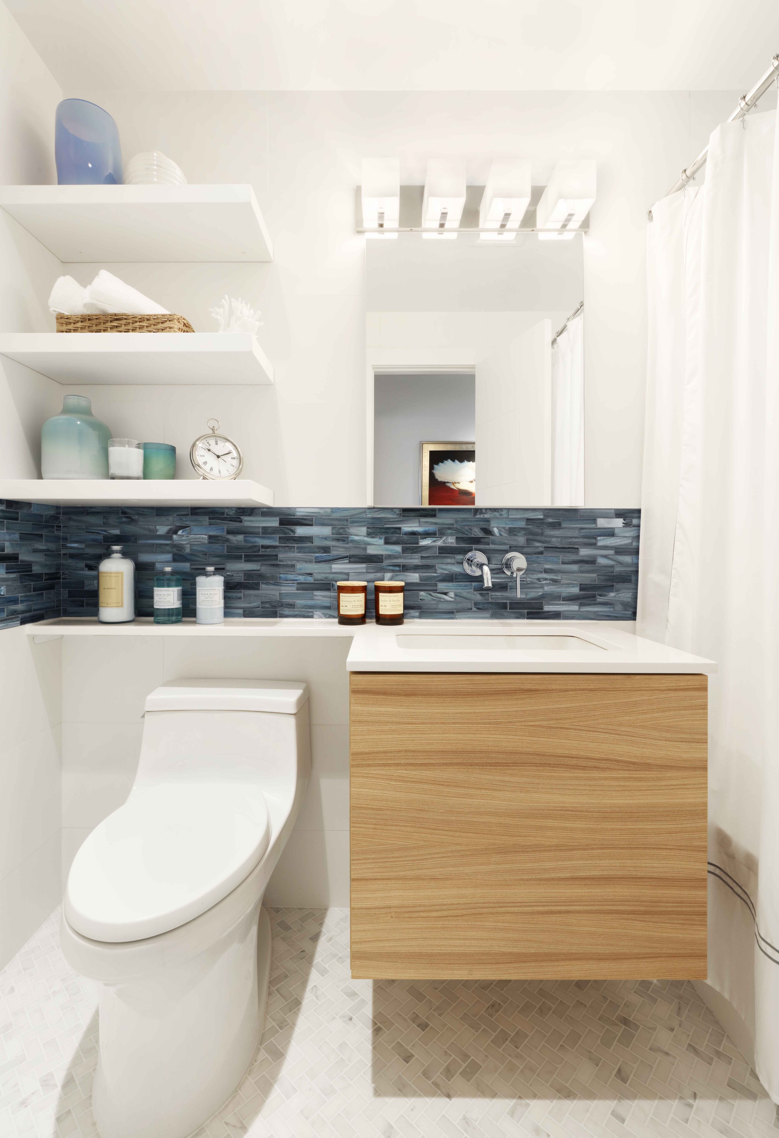 Family bathroom with streamlined vanity, wall-mounted fixtures in Doyer Apartment in White Plains, NY.