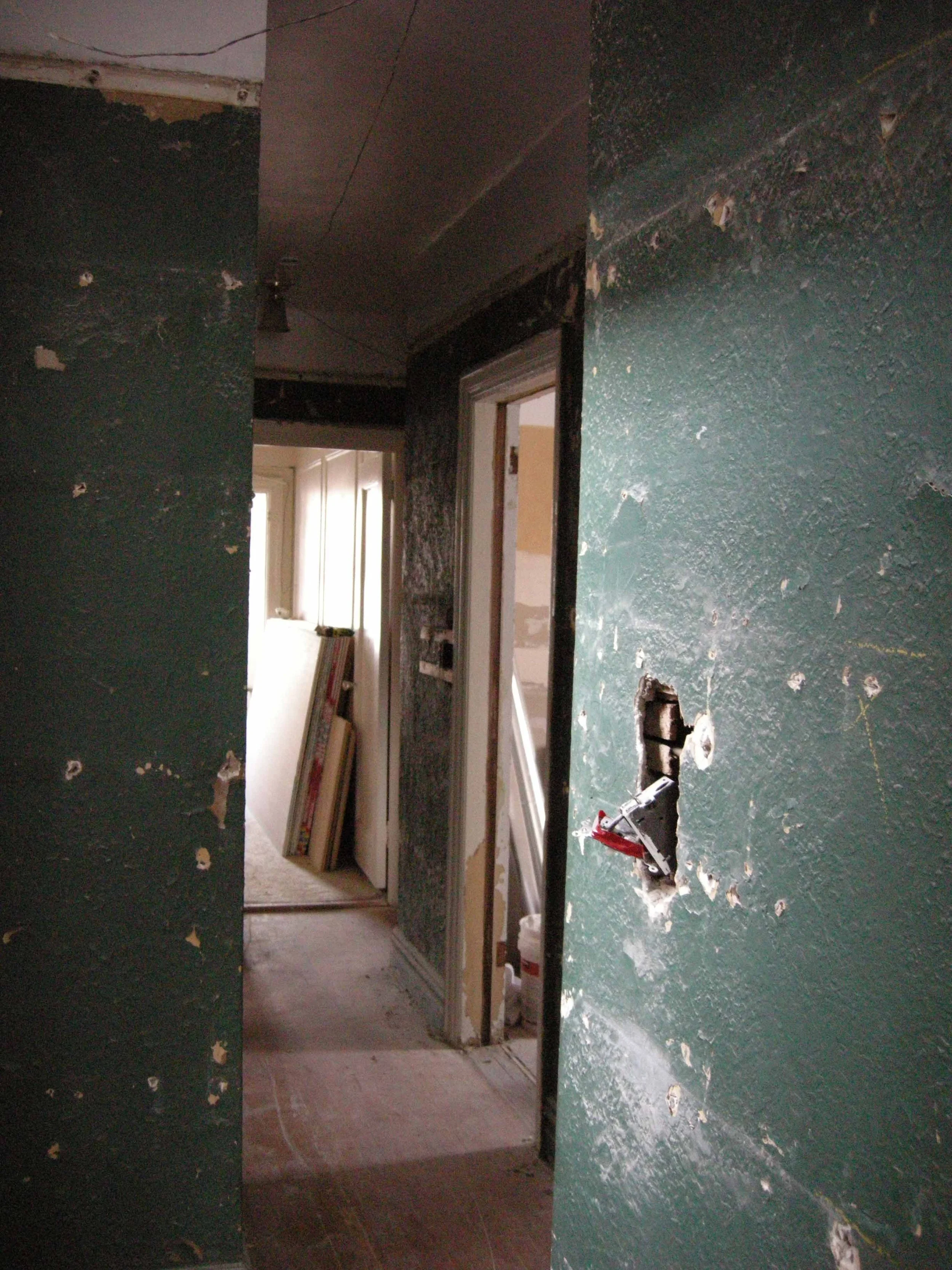 Before construction view of an older home renovation with opened walls and existing site conditions