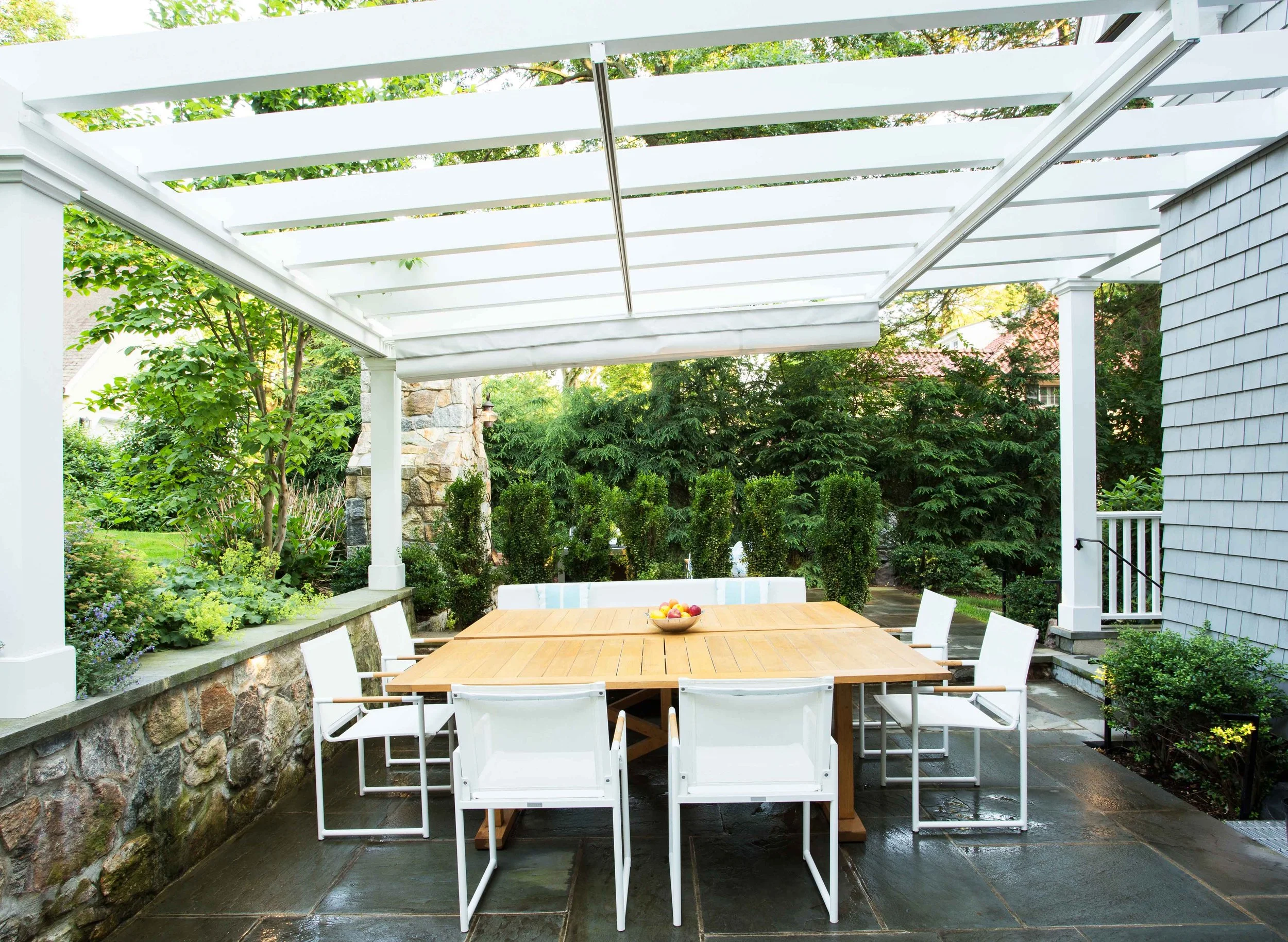 Alternate view of outdoor dining area with pergola shade retracted at the Indian Field Outdoor project in Greenwich, CT.