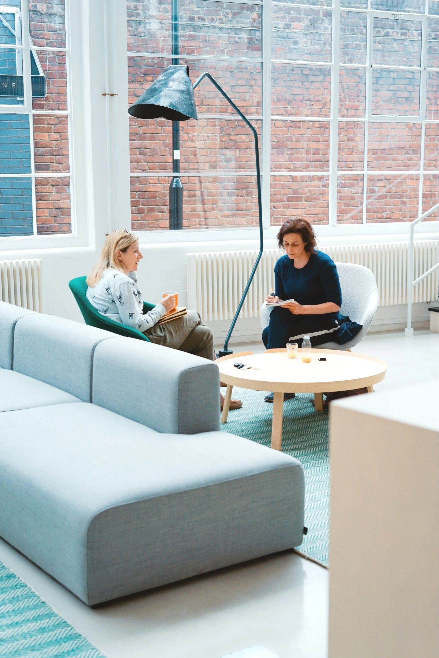 two women sitting together in a meeting