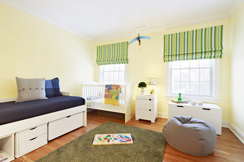 Nursery design for the Old Wagon project in Old Greenwich, CT featuring a white crib, built-in daybed, and soft yellow walls by Luminosus Designs.