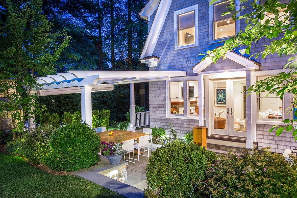Wide view of custom wrap-around pergola and dining area at the Indian Field Outdoor project in Greenwich, CT, designed by Luminosus Designs.