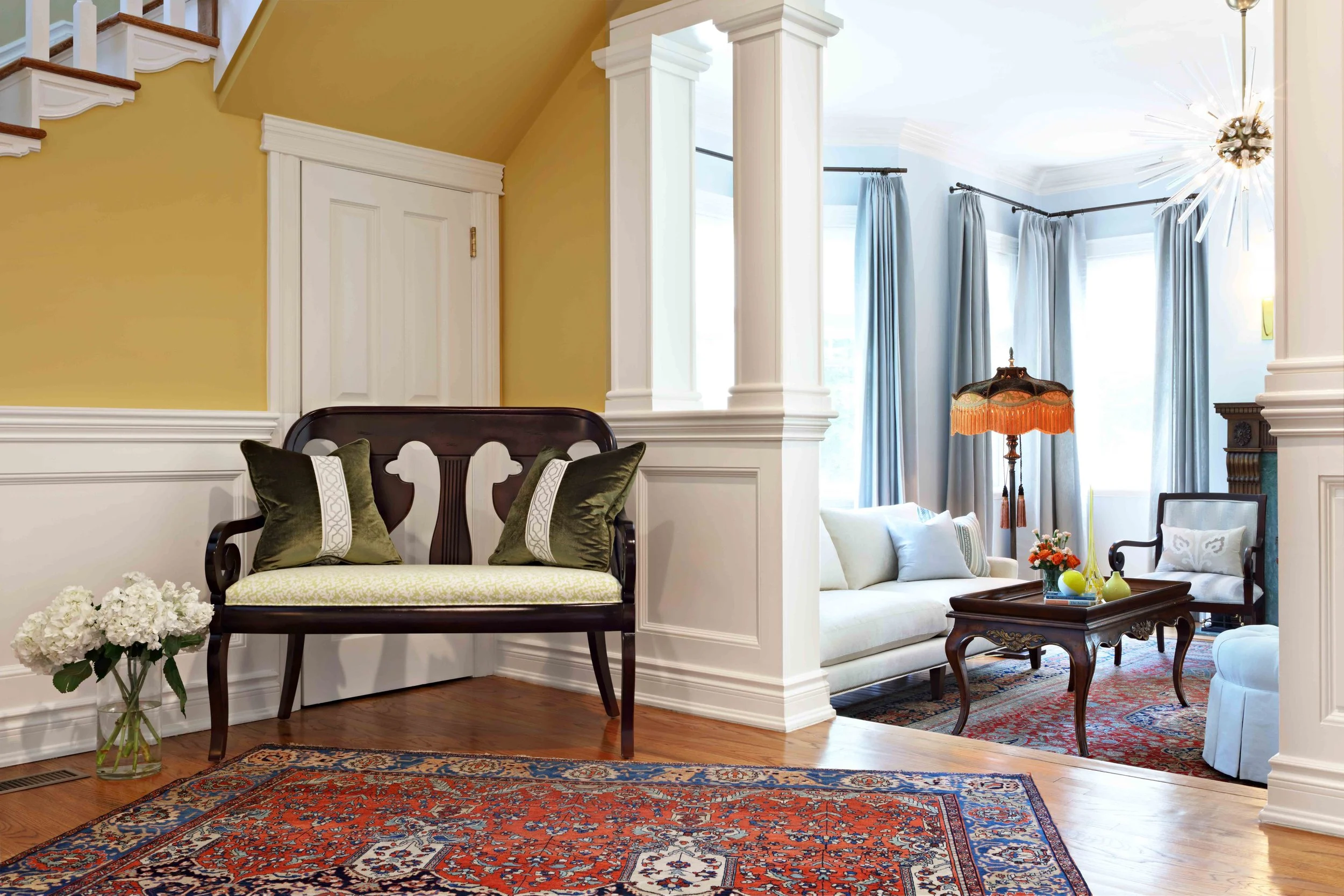 Foyer featuring entry seating and columns at Lismore House in Greenwich, Connecticut by Luminosus Designs.