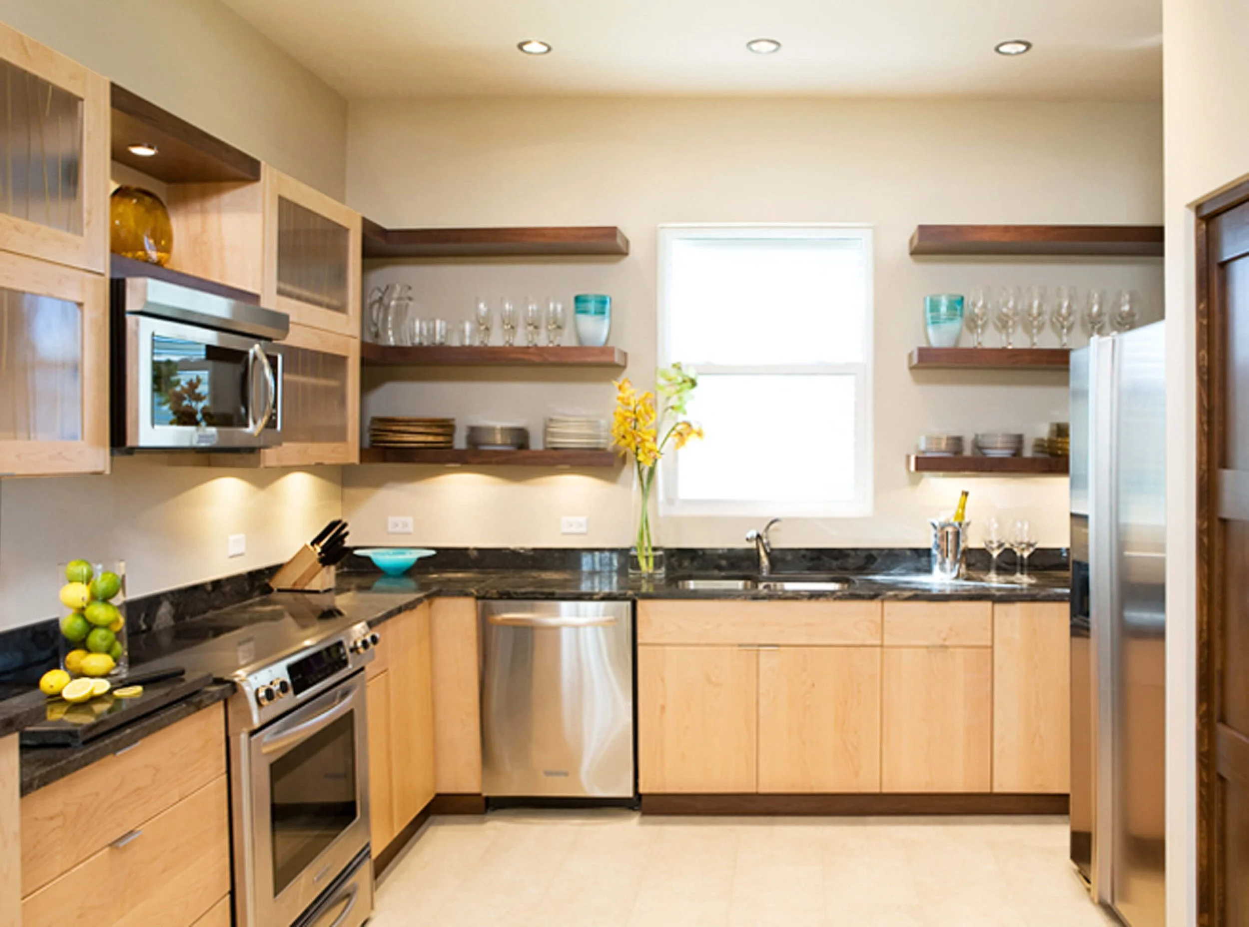 Fully equipped kitchen in Grand Cayman guest villa with wood cabinetry and open shelving.