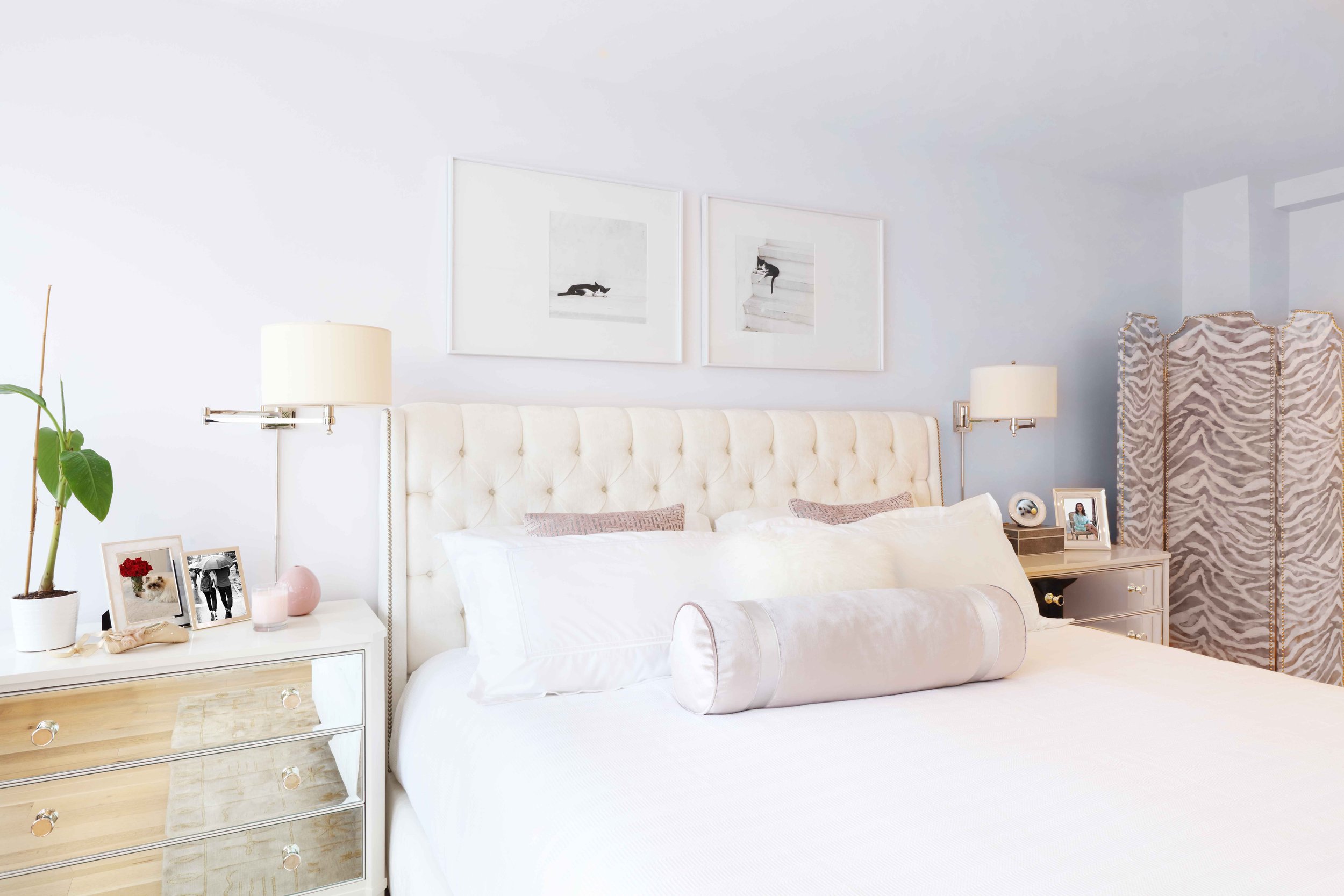 Primary bedroom with refined furnishings and upholstered screen in Doyer Apartment in White Plains, NY.