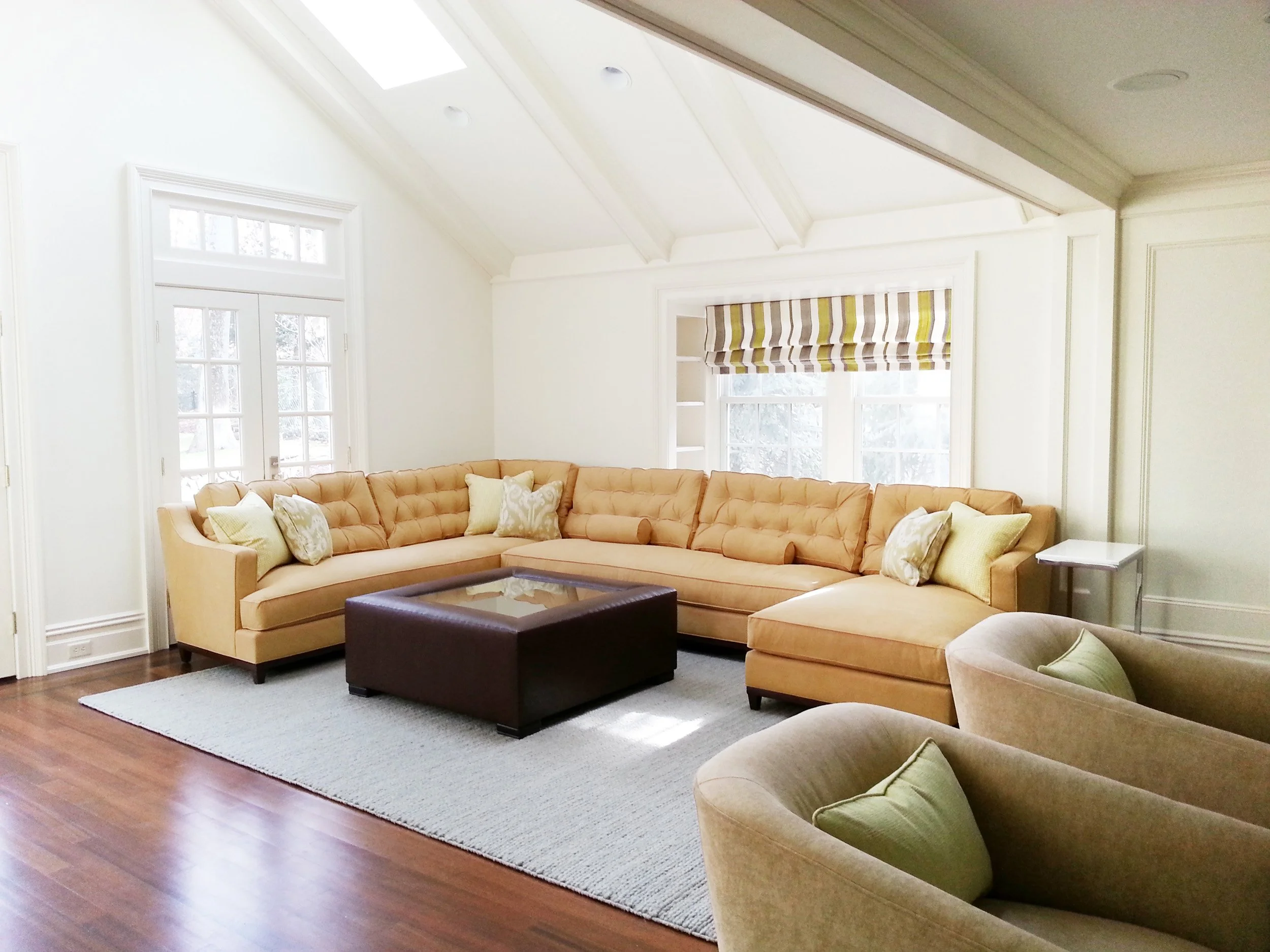 family room at the haworth residence in Haworth, NJ featuring large sectional sofa and generously sized coffee table designed by Luminosus Designs.