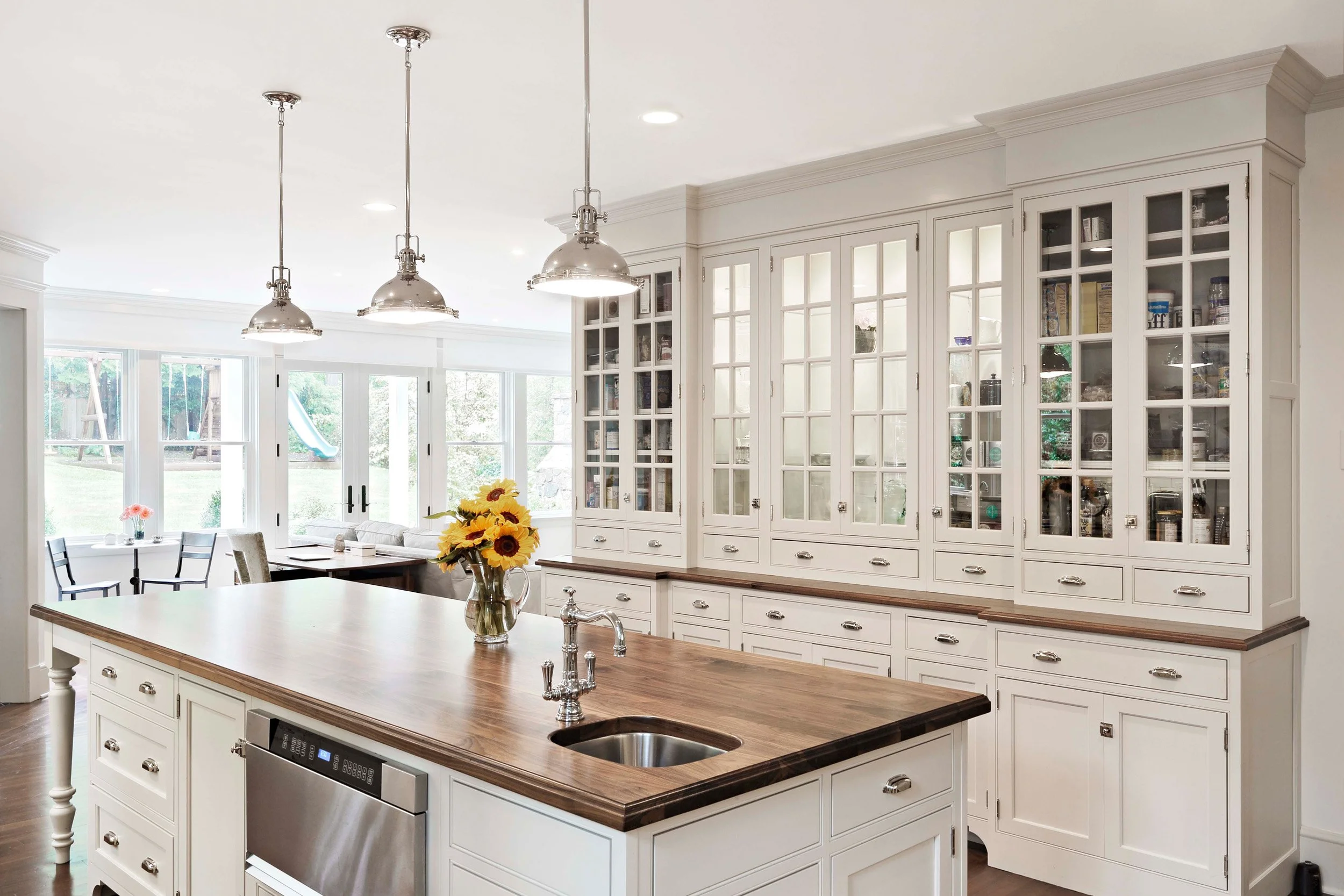 Kitchen lighting design in Indian Field residence in Greenwich, CT by Luminosus Designs highlighting island and ceiling fixtures.