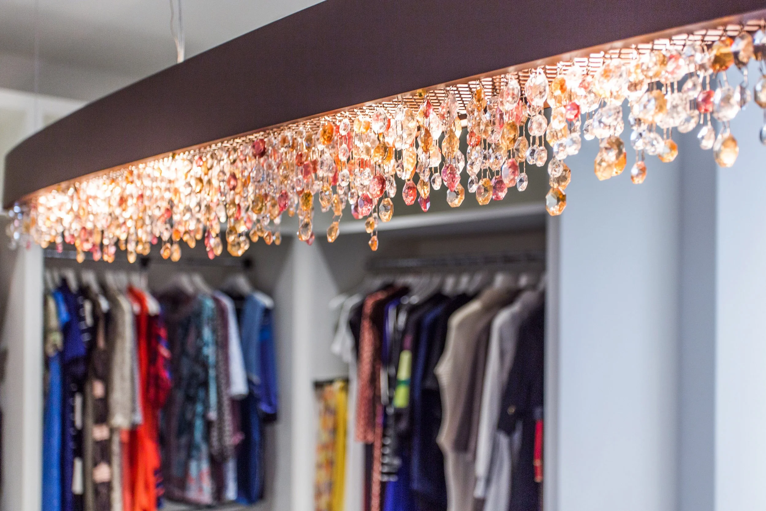Detail shot of the crystal chandelier with warm, faceted drops over the closet island in Kensett residence, Darien CT.