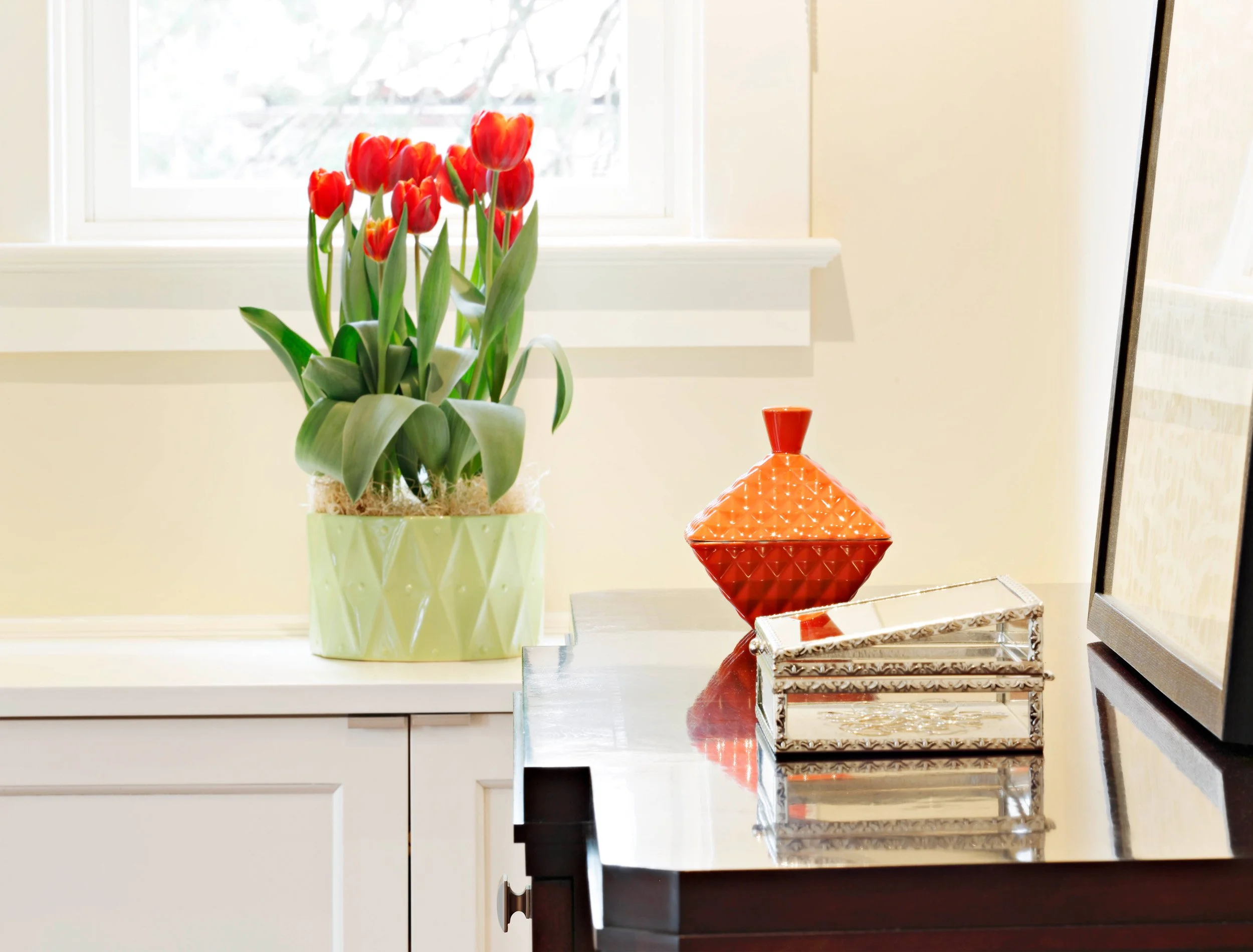 Dresser detail styled beneath window in primary bedroom in Indian Field residence in Greenwich, CT.