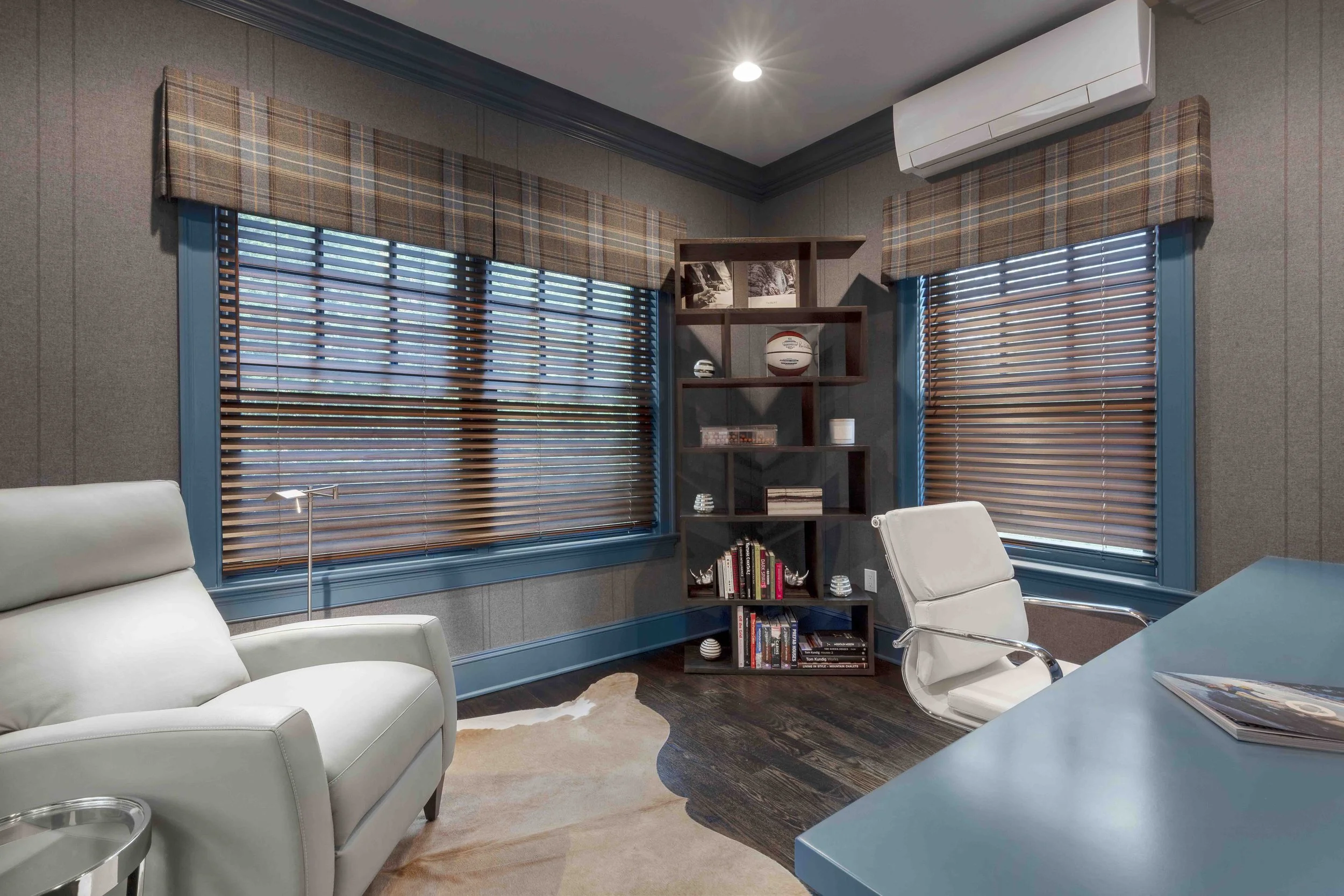 Close-up of the bookcase, window treatment, and reclining chair in the Glen Oaks home office in Rye, NY.