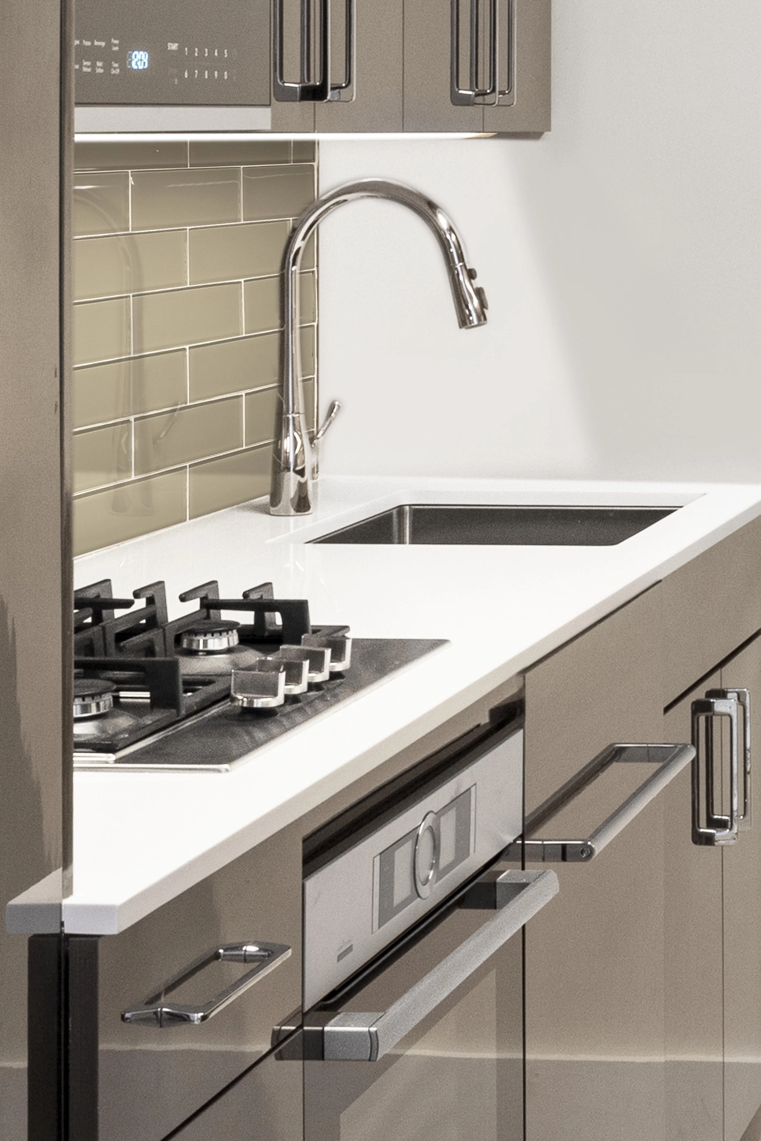 Close-up of the cooktop, sink, hardware, and surrounding finishes in the Gramercy Arms, NYC kitchen.