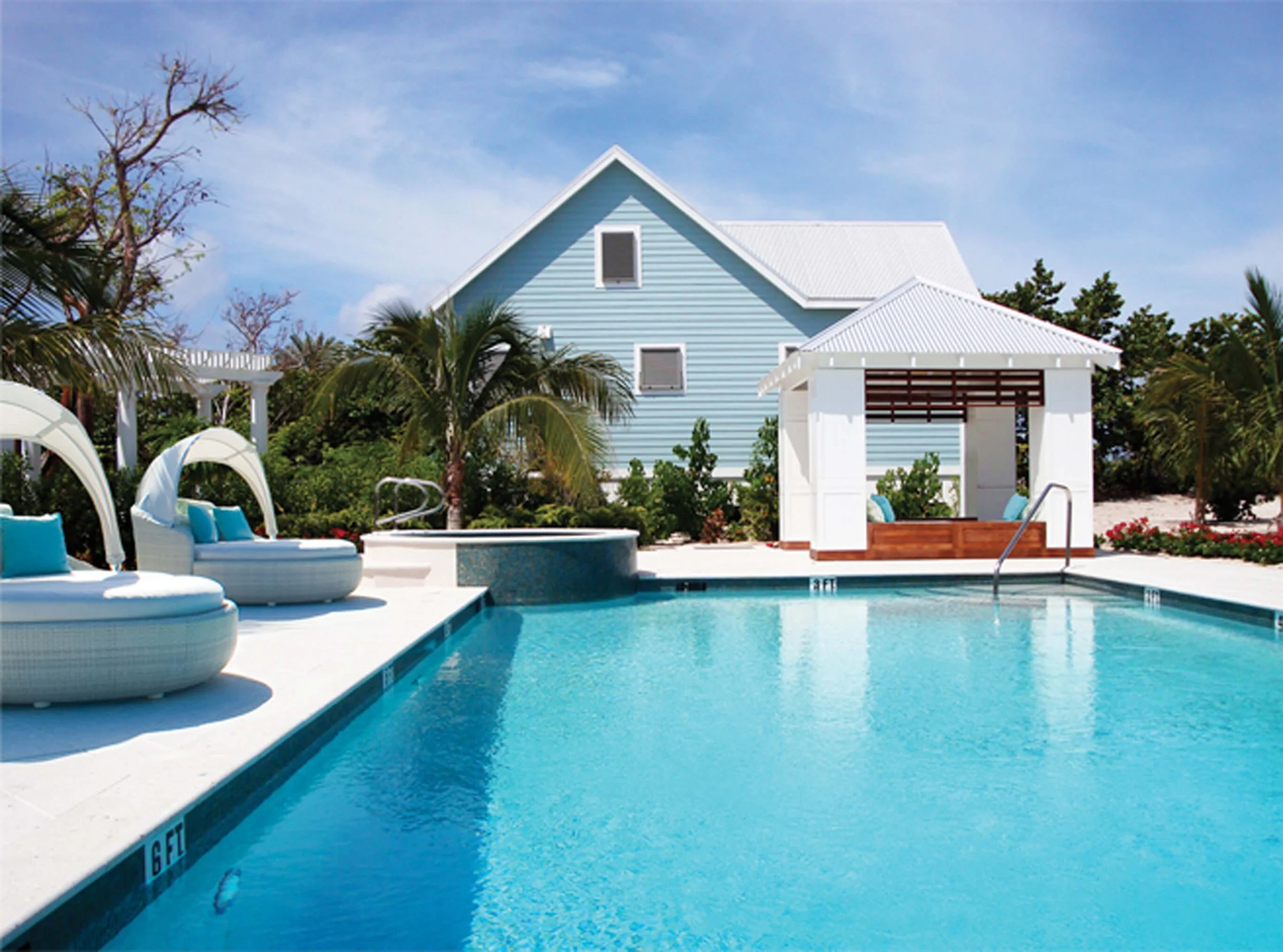Outdoor pool and lounge area at Cotton Tree Grand Cayman with cabana seating.