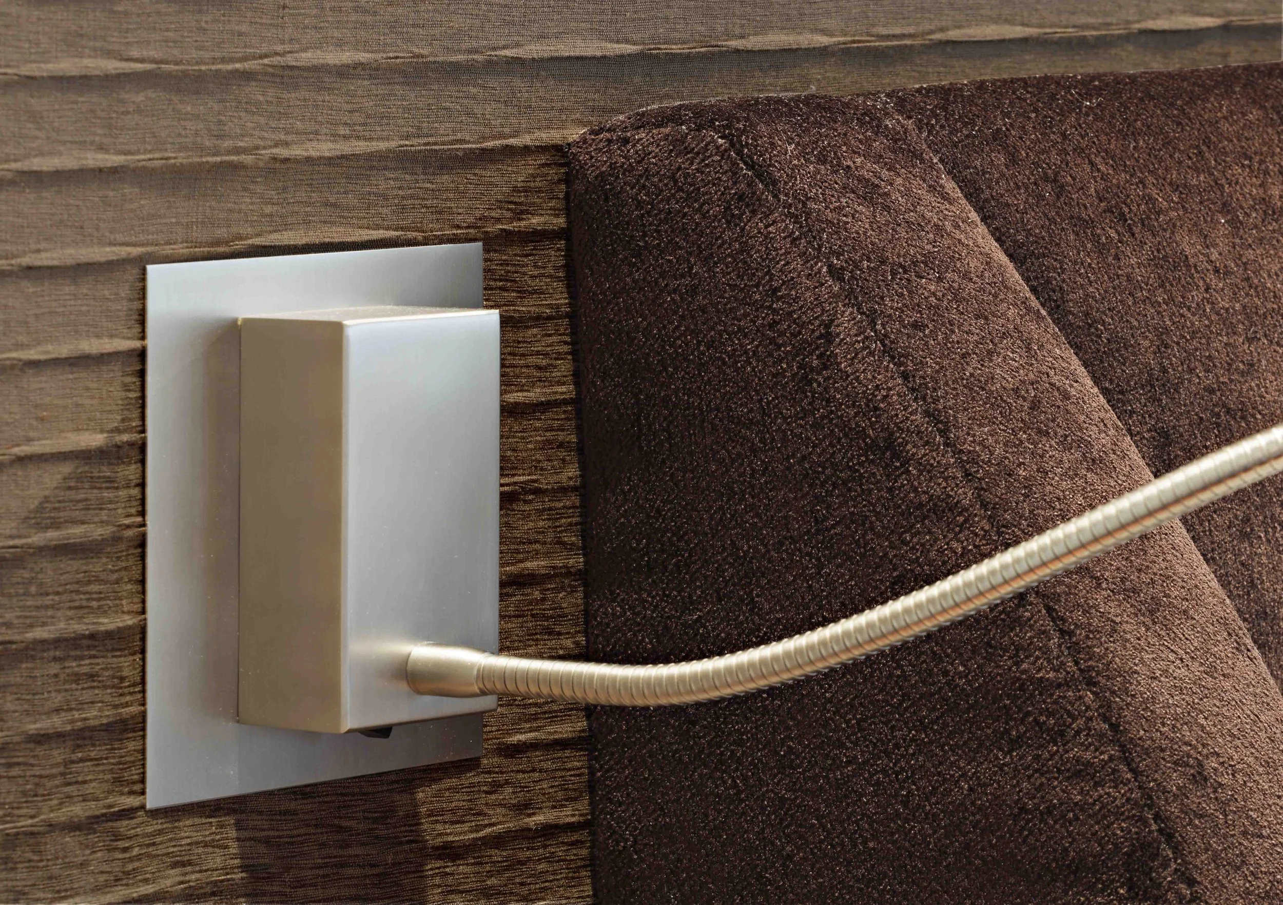 Adjustable reading light mounted beside the bed.