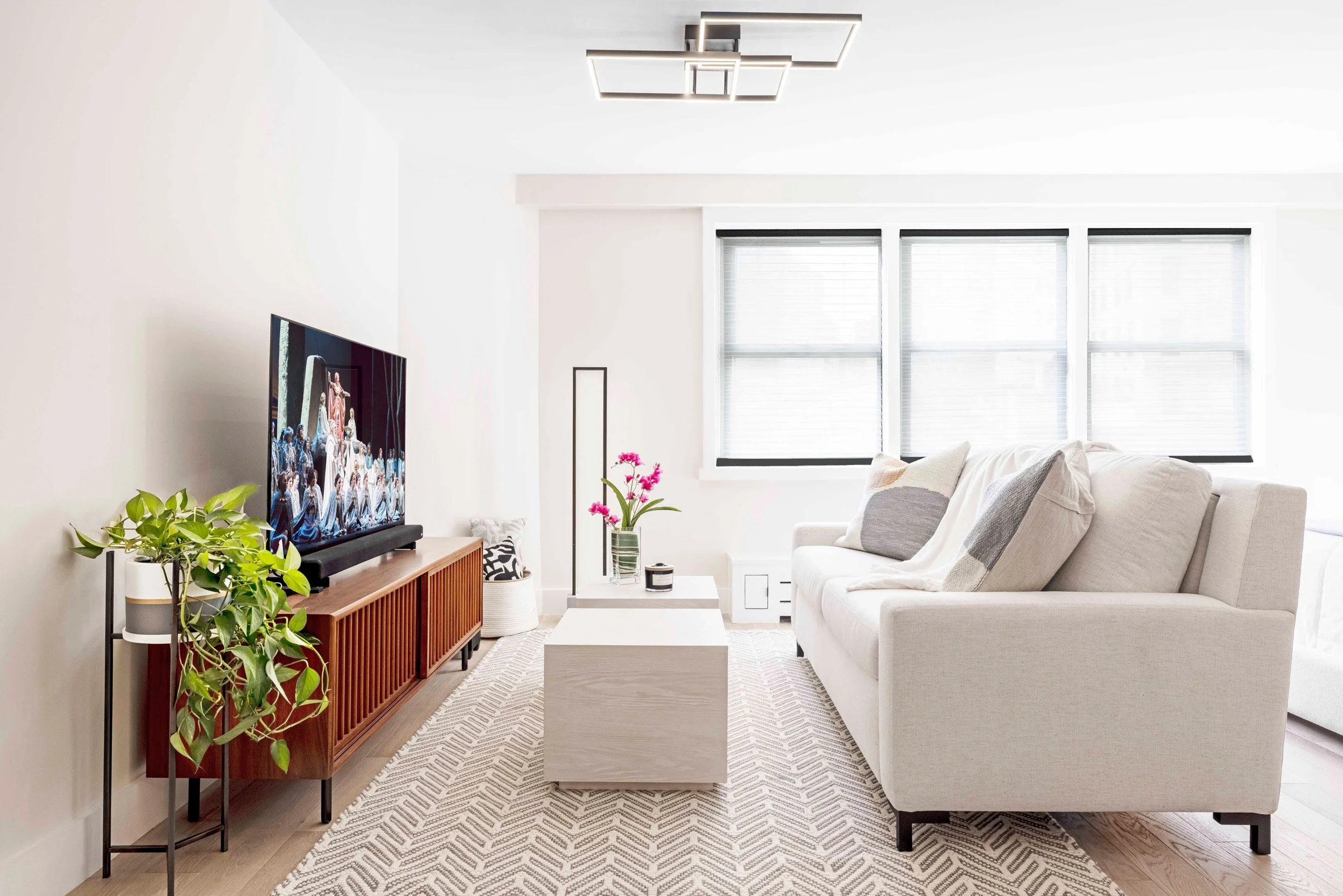 Close-up view of calm living area featuring sleeper sofa, movable coffee tables, and media console in the Gramercy Arms apartment, NYC by Luminosus Designs.