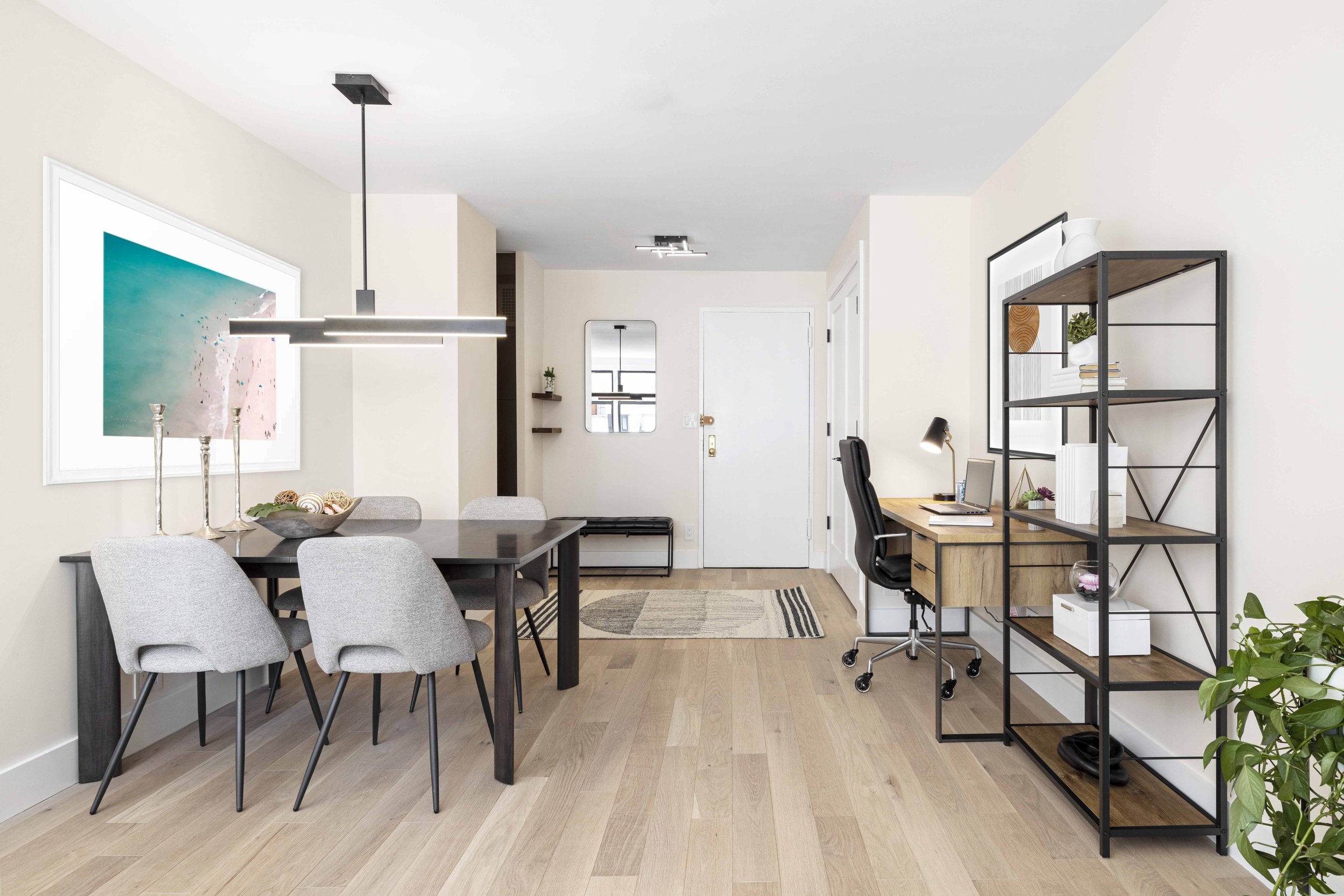 Wide view of the Gramercy Arms apartment in New York City, showing dining area, desk area, and foyer.