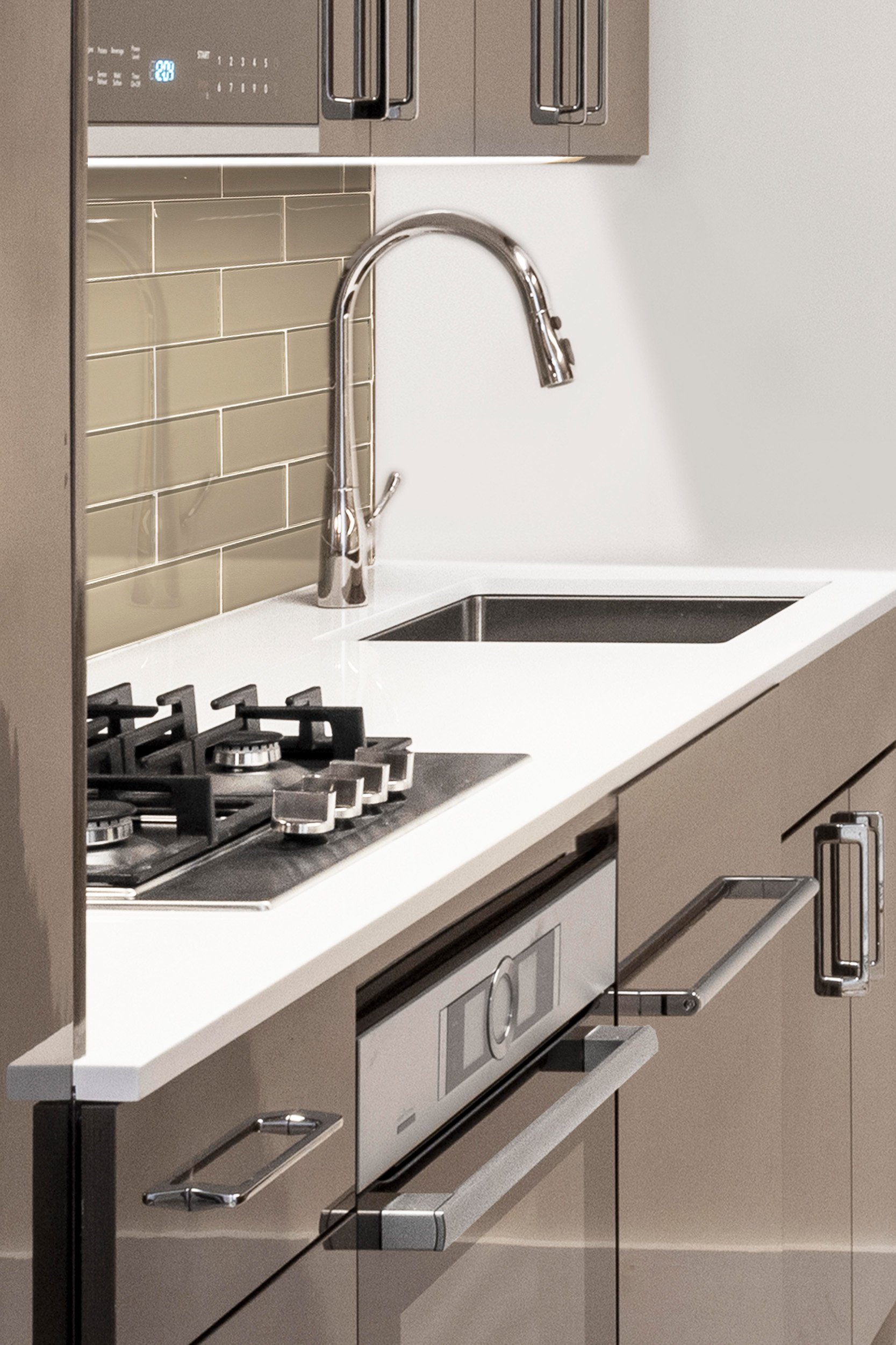 Close-up of the cooktop, sink, hardware, and surrounding finishes in the Gramercy Arms, NYC kitchen.